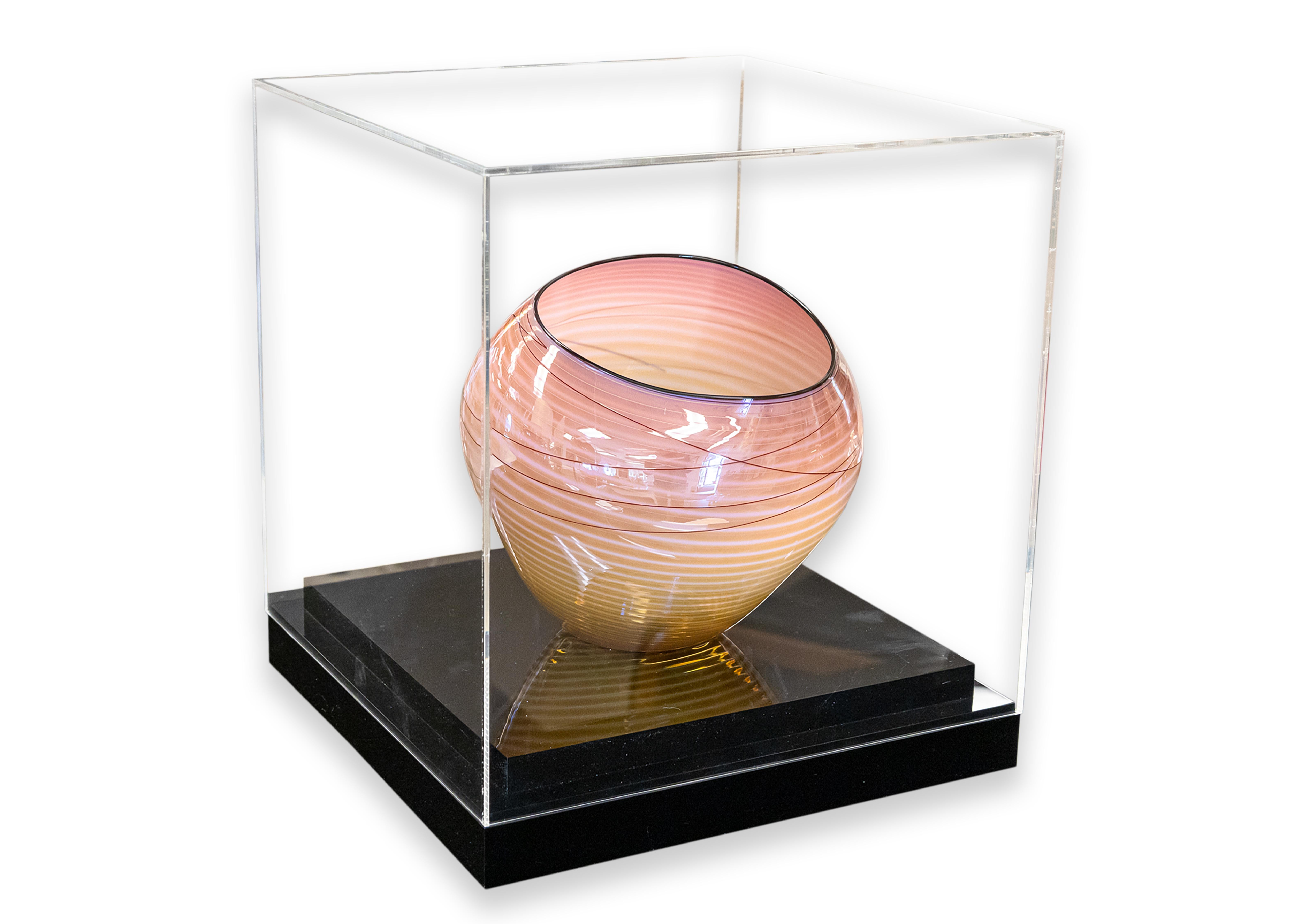 A vibrant hand-blown coral “Basket” vase by Dale Chihuly. Etched signature on underside. Published by Portland Press, 1998. A unique asymmetrical composition with a swirled stripe design. For this series, Chihuly takes inspiration from Native