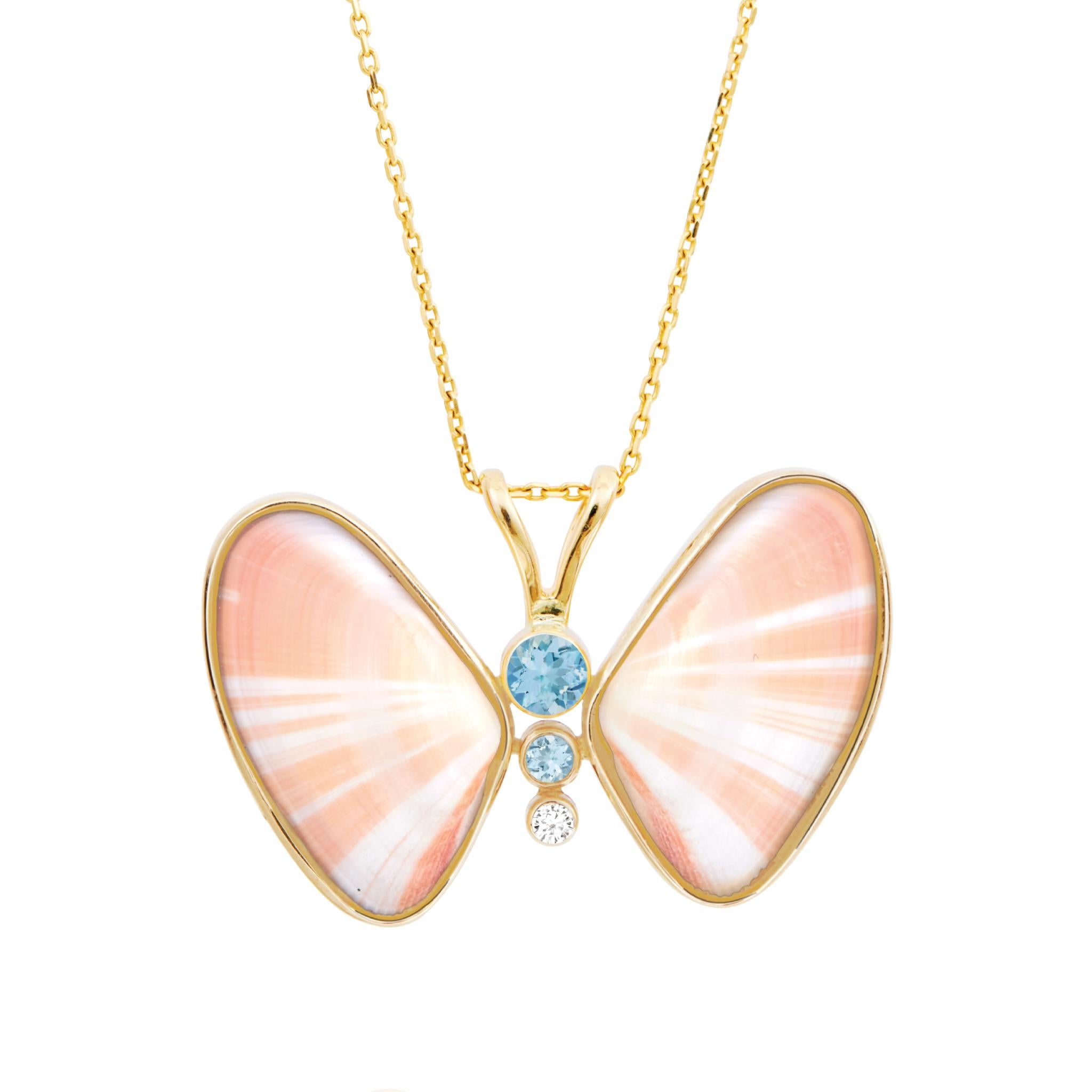 Dalia Butterfly Necklace is a luxurious fine jewelry piece made of shell with natural diamond and blue topaz gemstones, set in a handmade 14k gold setting. Inspired by surrealism, this whimsical piece reimagines shells found in the ocean and