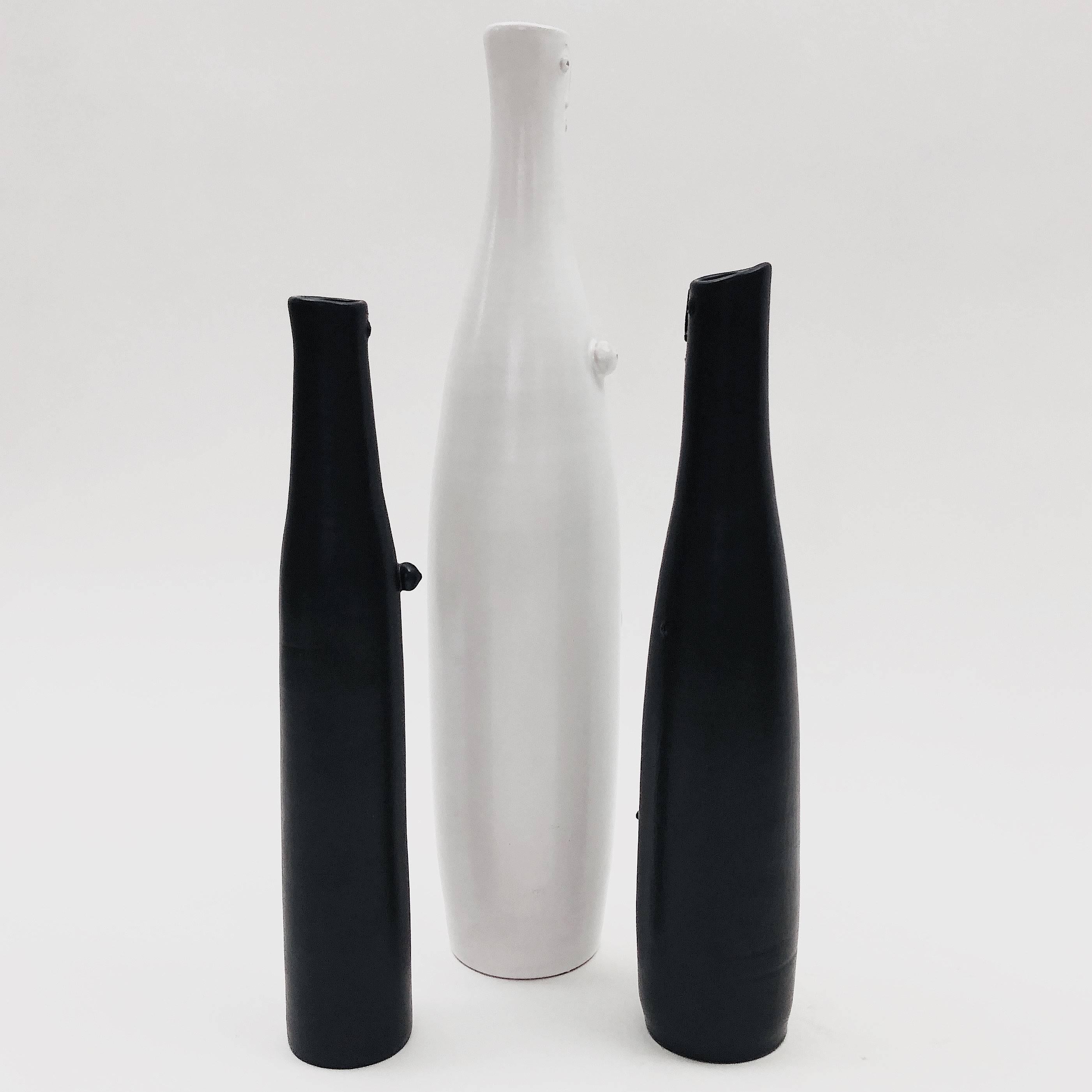 Set of bottle-vases, organic and figurative shaped, ceramic glazed in white and black, decorated with stylized and naked male and female characters in front.

One of kind handmade pieces, signed by the French ceramicists, the Dalo.

The