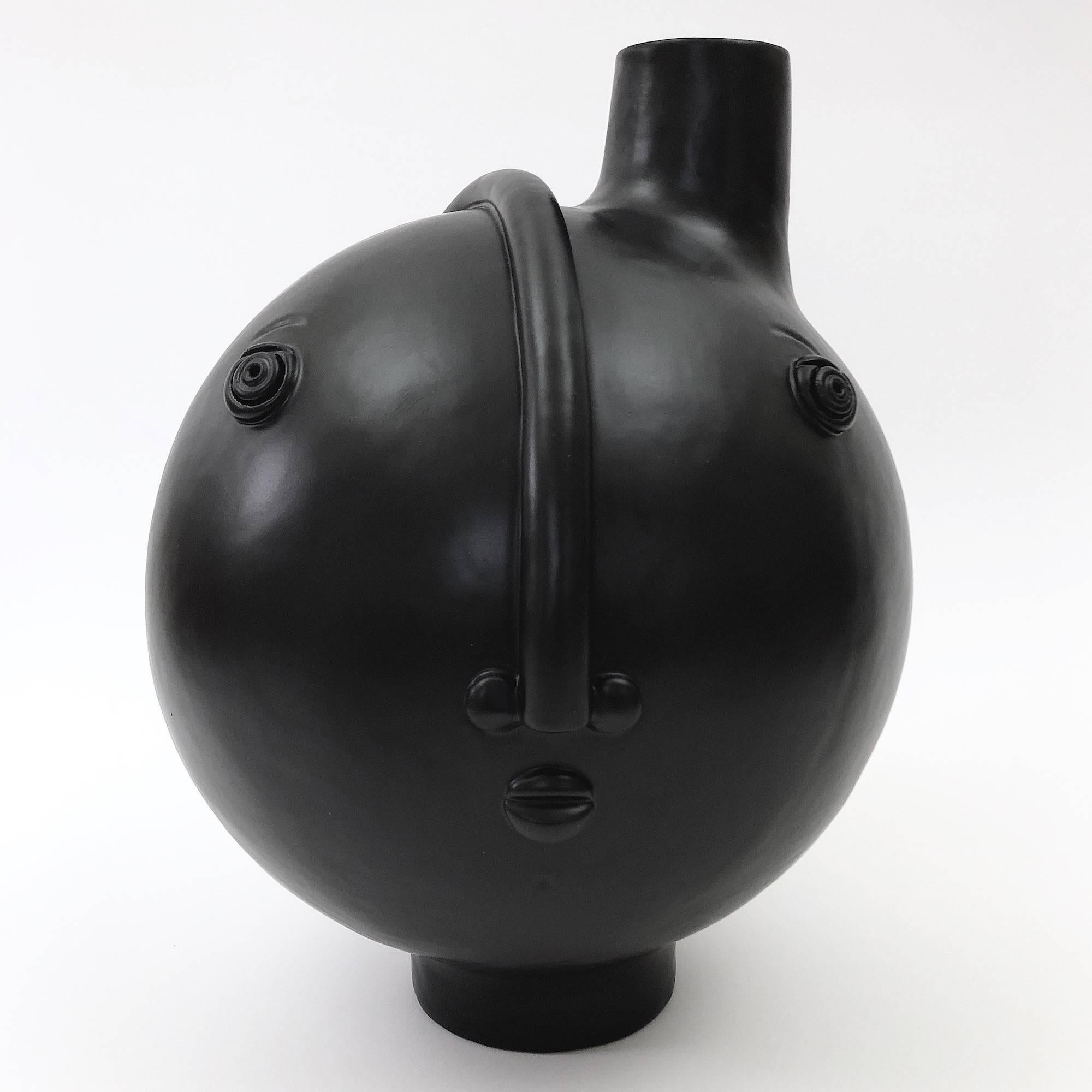 Sculptural and figurative pottery piece forming a table lamp base.
Ceramic glazed in matt black, decorated with a stylized visage in front.
One of a kind handmade piece signed by the French artists ceramicists, Dalo. 

Dimensions:
The height