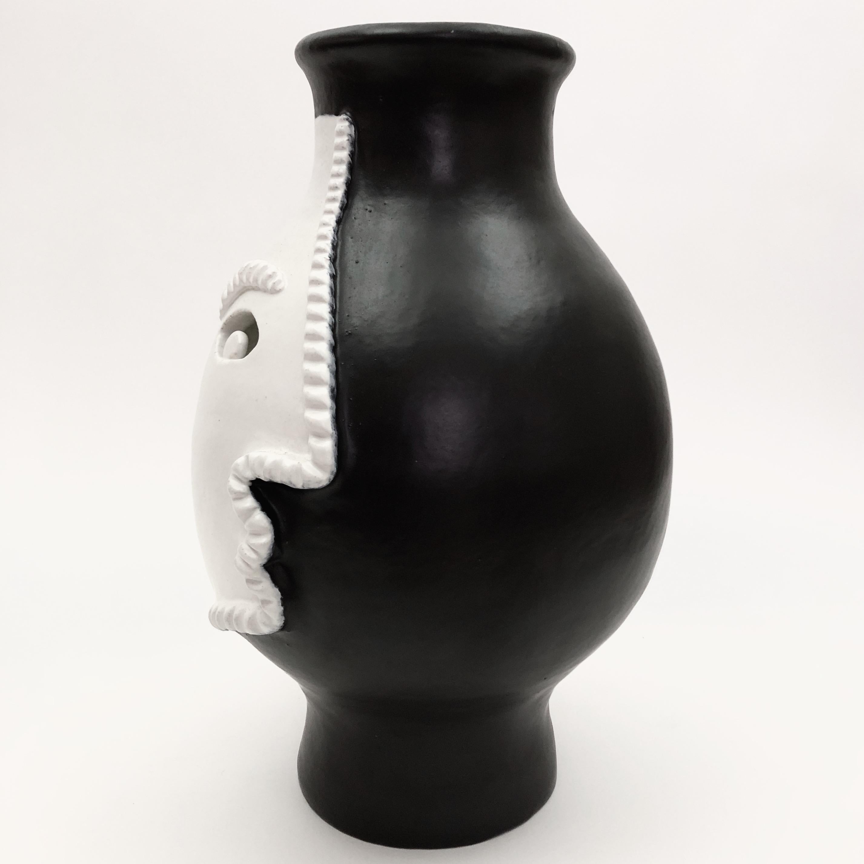 Impressive sculptural piece forming a large baluster vase
Ceramic glazed in matt black and white, decorated with a stylized visage incised and sculpted. 
One of a kind handmade piece designed and signed by the French artists and ceramicists: Dalo.