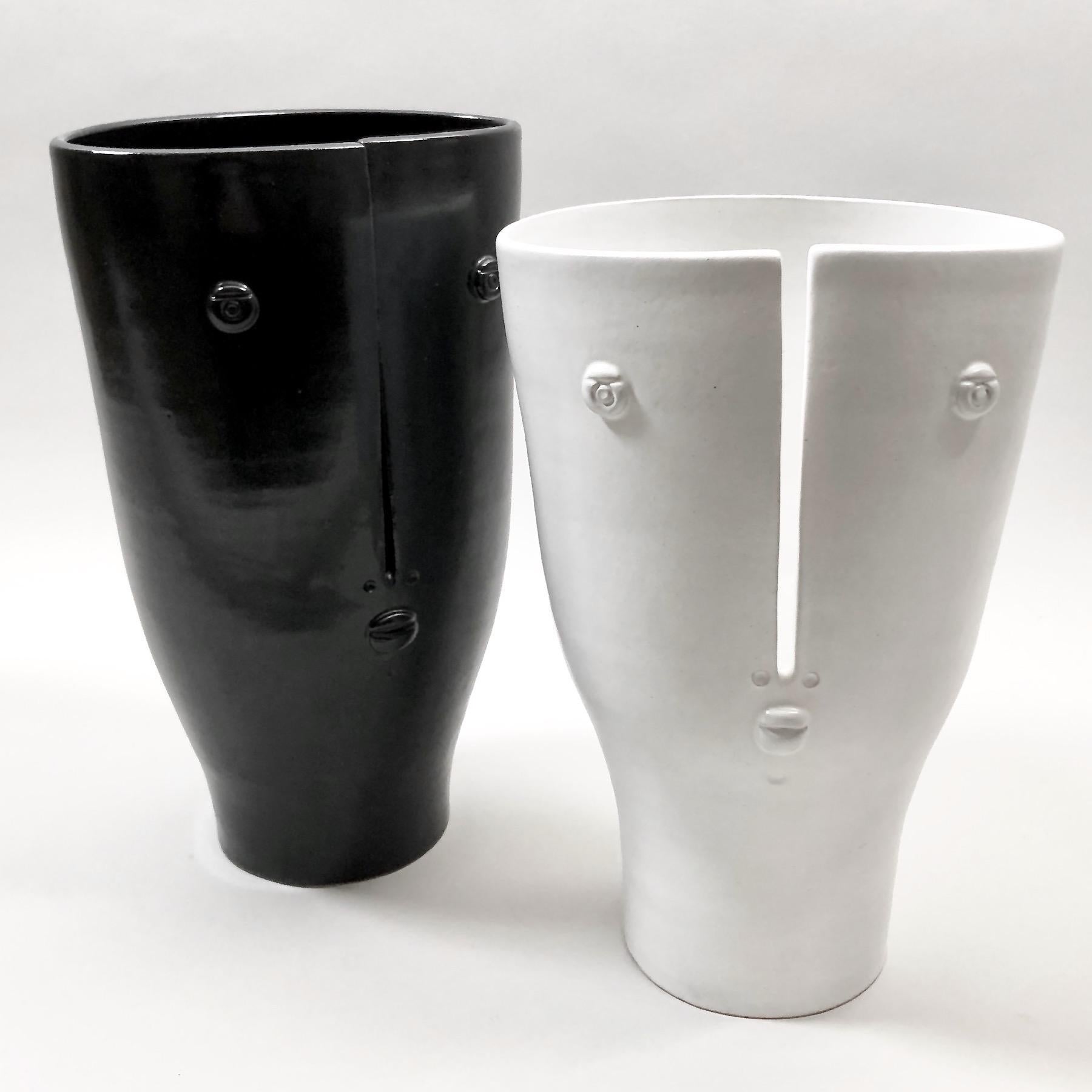 Figurative vases, called Idoles, ceramic enameled in black and white, decorated with stylized visages sculpted and incised front. 
One of a kind and exclusive handmade pieces, designed and signed by the French artists and ceramicists: Dalo