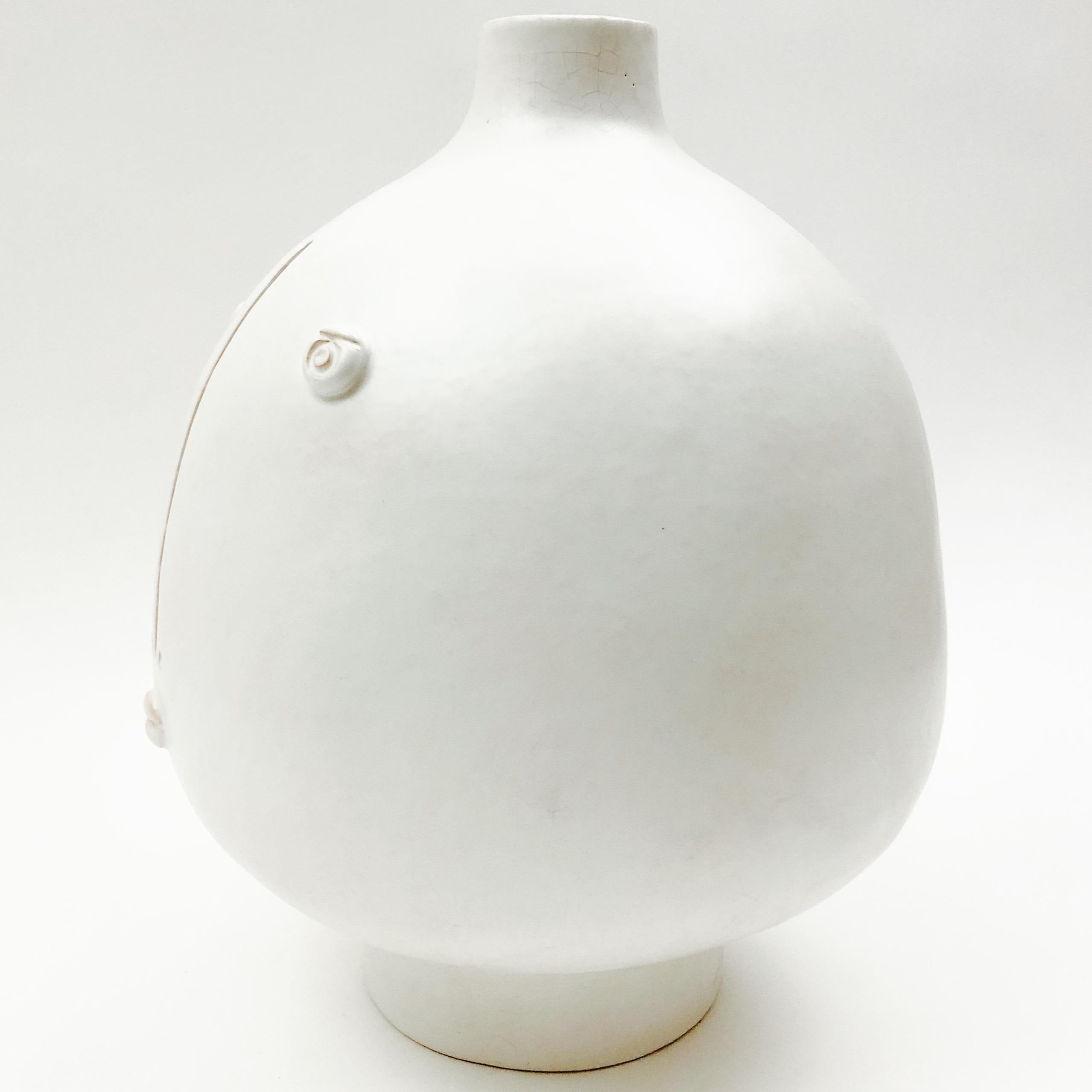 Sculptural pottery piece forming table lamp-base.
Ceramic glazed in matt white, decorated with a stylized visage sculpted and engraved front.
One of a kind handmade piece signed by the French artists ceramicists: Dalo.

Dimensions:
The height