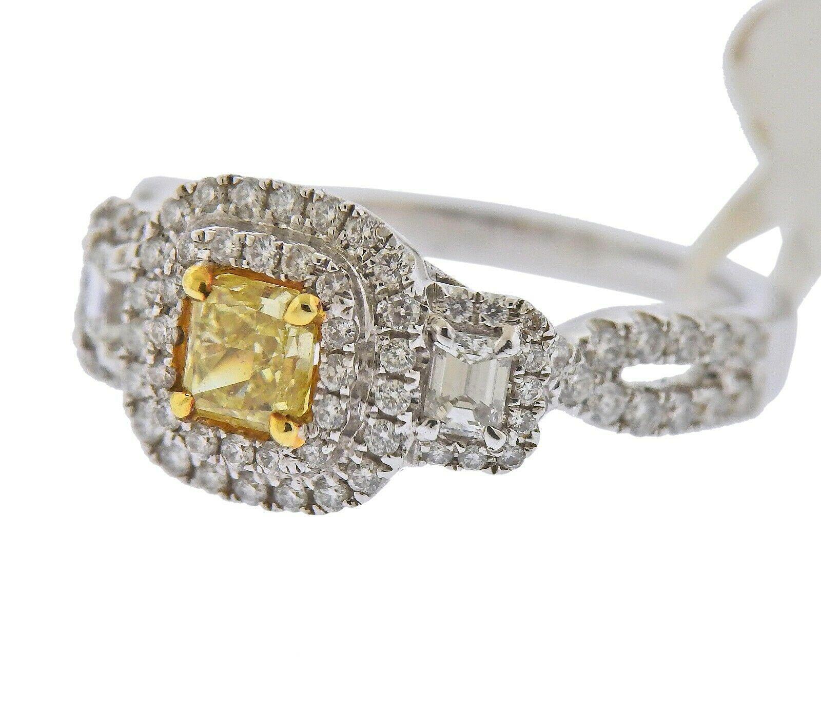 18k white gold engagement ring by Dalumi. Set with a 0.58ct Radiant cut VS1/ fancy yellow diamond in the center, surrounded by 0.72ctw of VS1/H diamonds. retail $7999. Ring size - 6.5, ring top - 10mm x 16mm. Marked - DG, 0.58ct, 18k, 750.. Weight