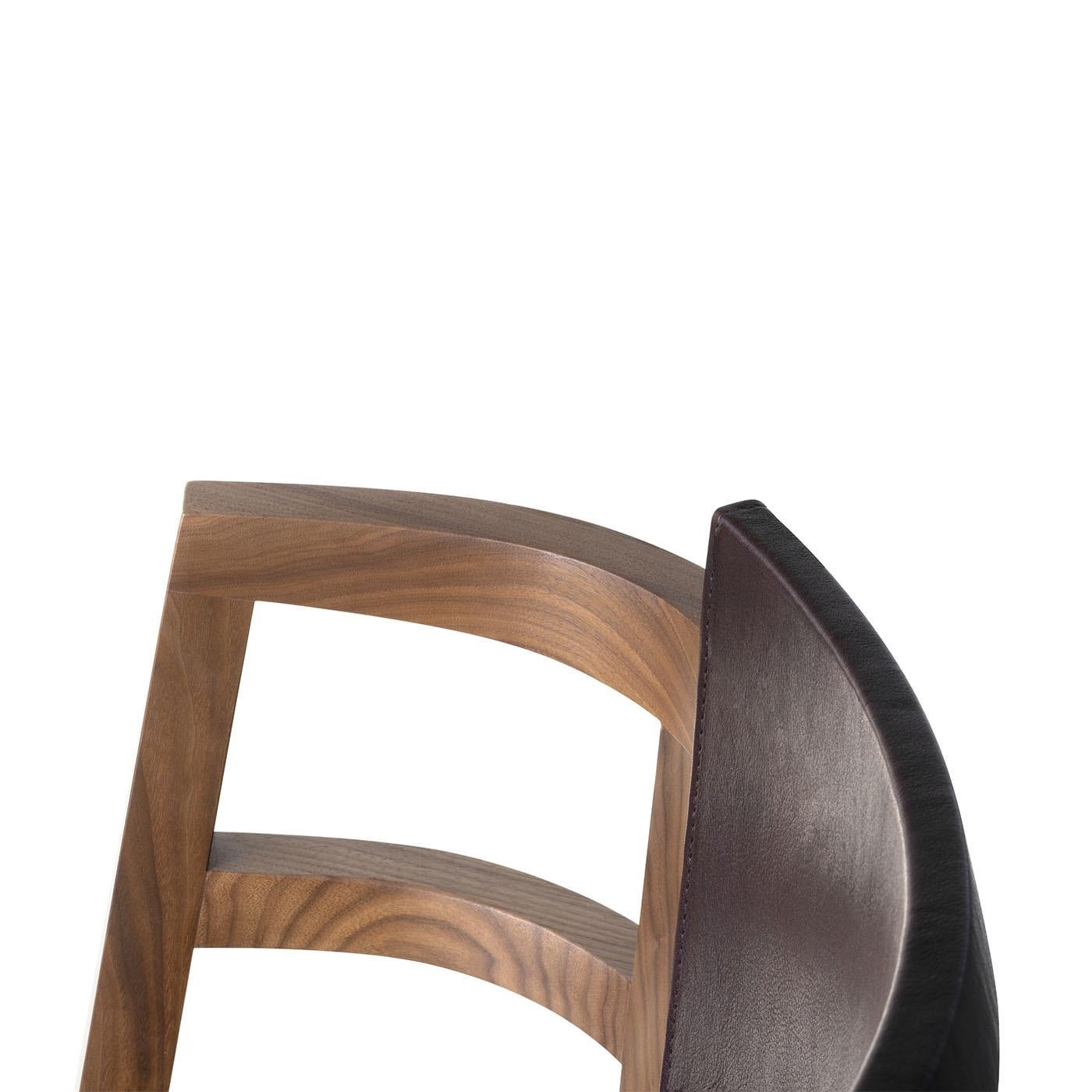 Dama small armchair is designed by Enrico Tonucci and it's characterized by minimalist lines inspired by the image of a pastime dame dressed in crinoline. It’s made of solid black walnut wood with the back and the seat in leather. Also available in