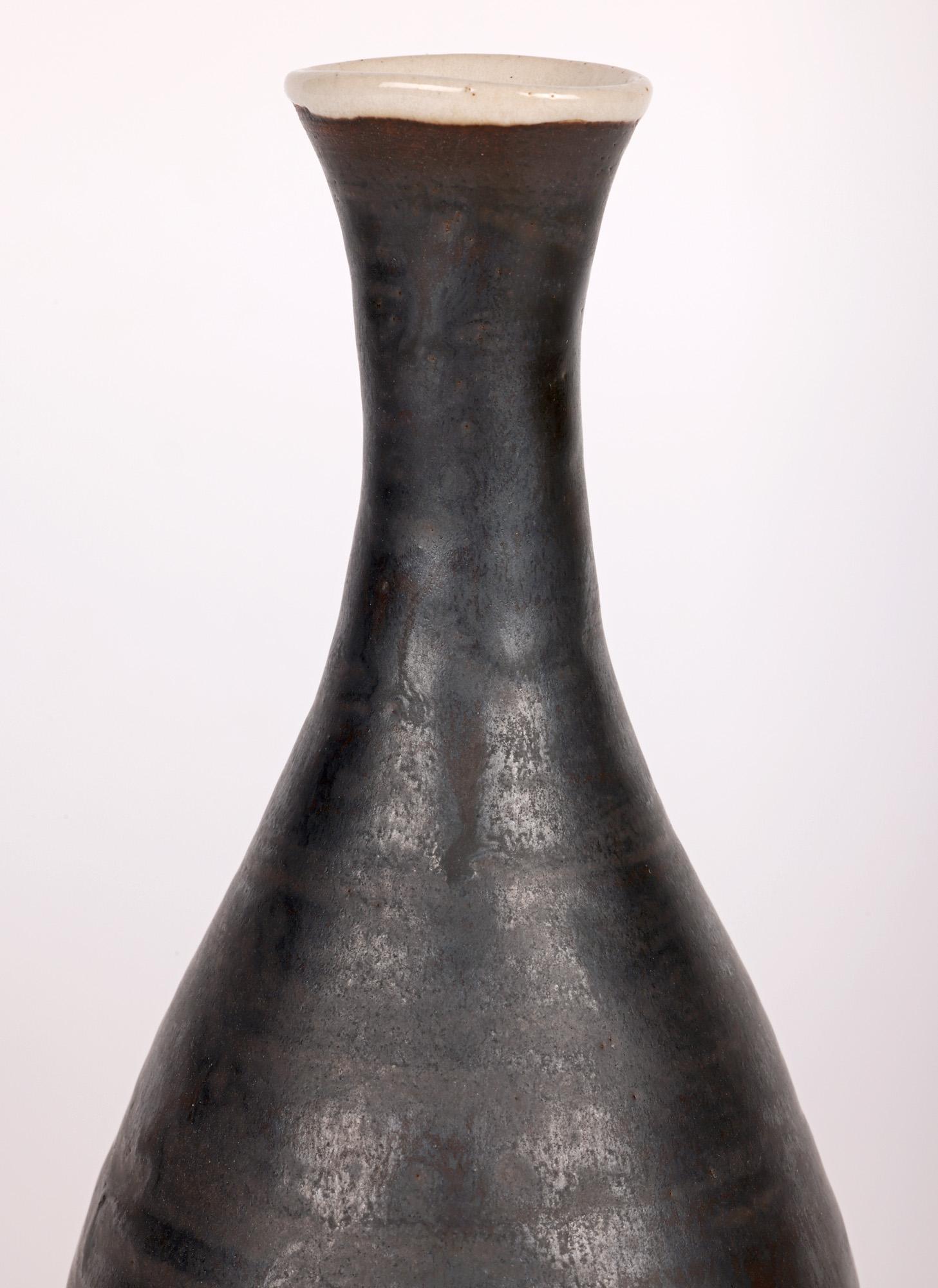 A scarce mid-century Studio Pottery Festival of Britain vase by renowned modernist potter Dame Lucie Rie (Austrian, 1902 – 1995) dated 1951. The bottle shaped vase stands on a round unglazed foot with slightly recessed base the body narrowing to a