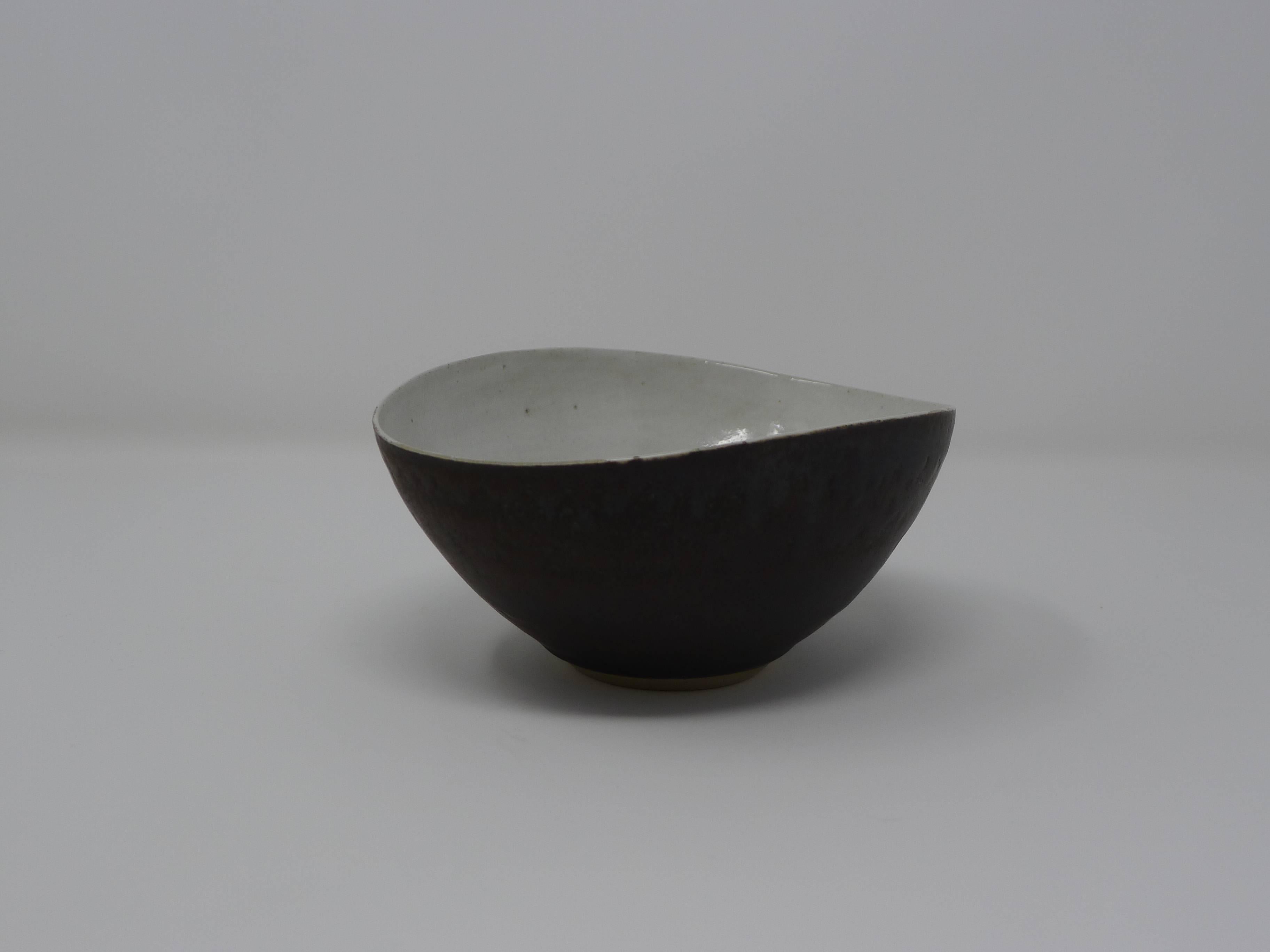 Dame Lucie Rie, Austria / UK. A stoneware bowl with white interior and manganese exterior, manufactured in the 1970s. The piece is signed to the underside as shown. 

Perfect condition.