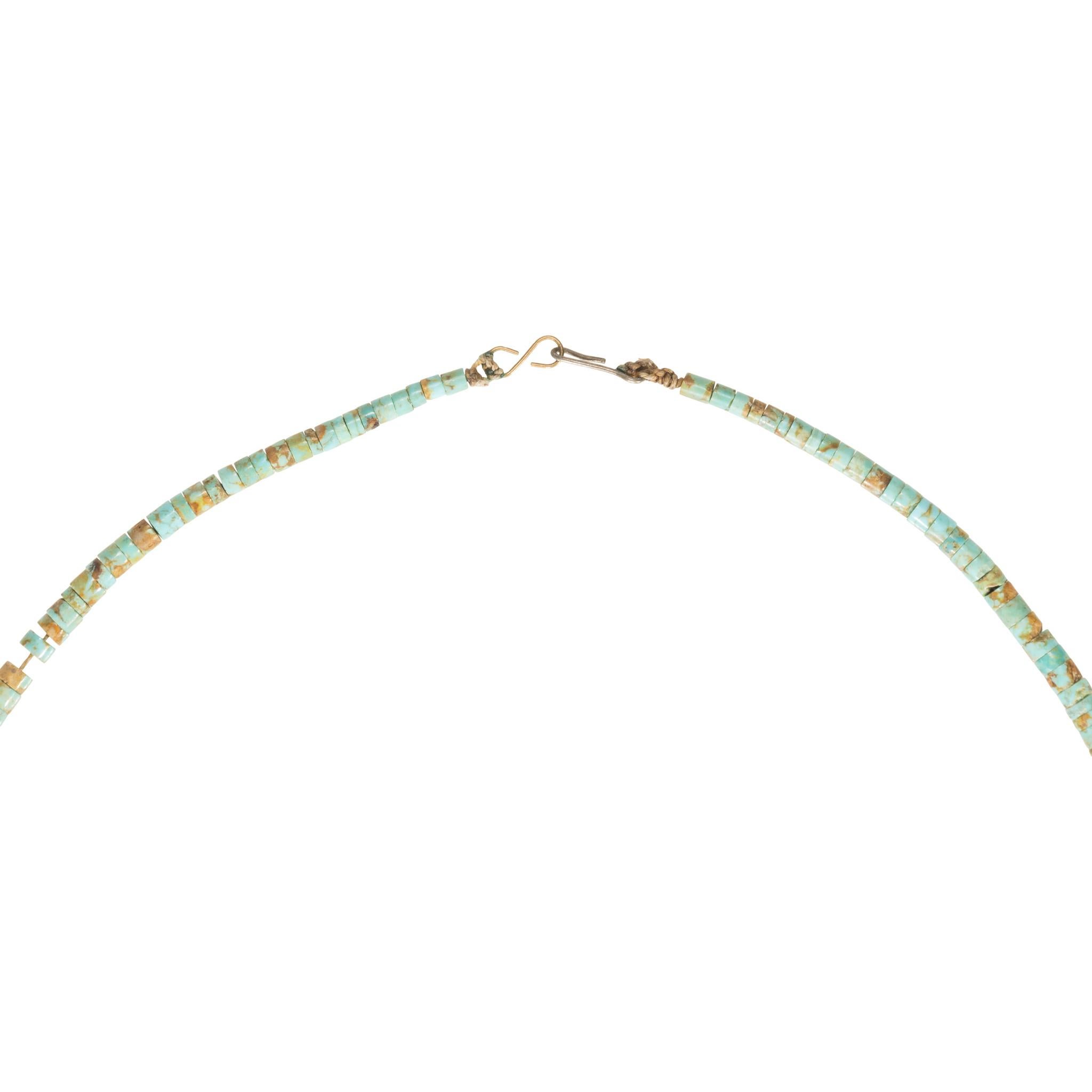 Damele turquoise beaded necklace. Large natural style turquoise stones interspersed with small turquoise disc beads. The stones are a beautiful light green color with brown and gold matrix across surface. Hoop closure. Great contemporary look,