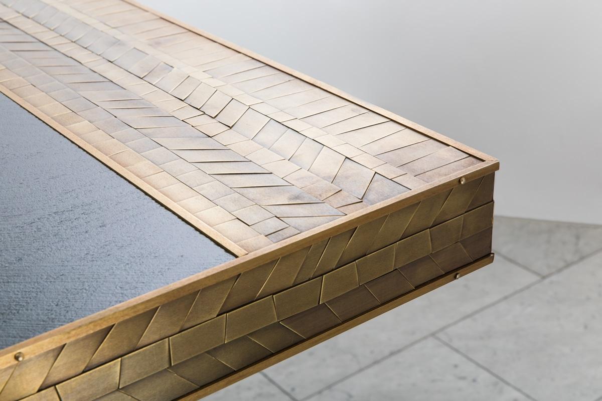 Damian Jones’s extraordinary Alltwen Table employs the artist’s penchant for bold forms with meticulous detailing.  The tables base is sheathed in a tessellated pattern of hand-cut and laid brass “tiles.” Each tile has been patinated in varied