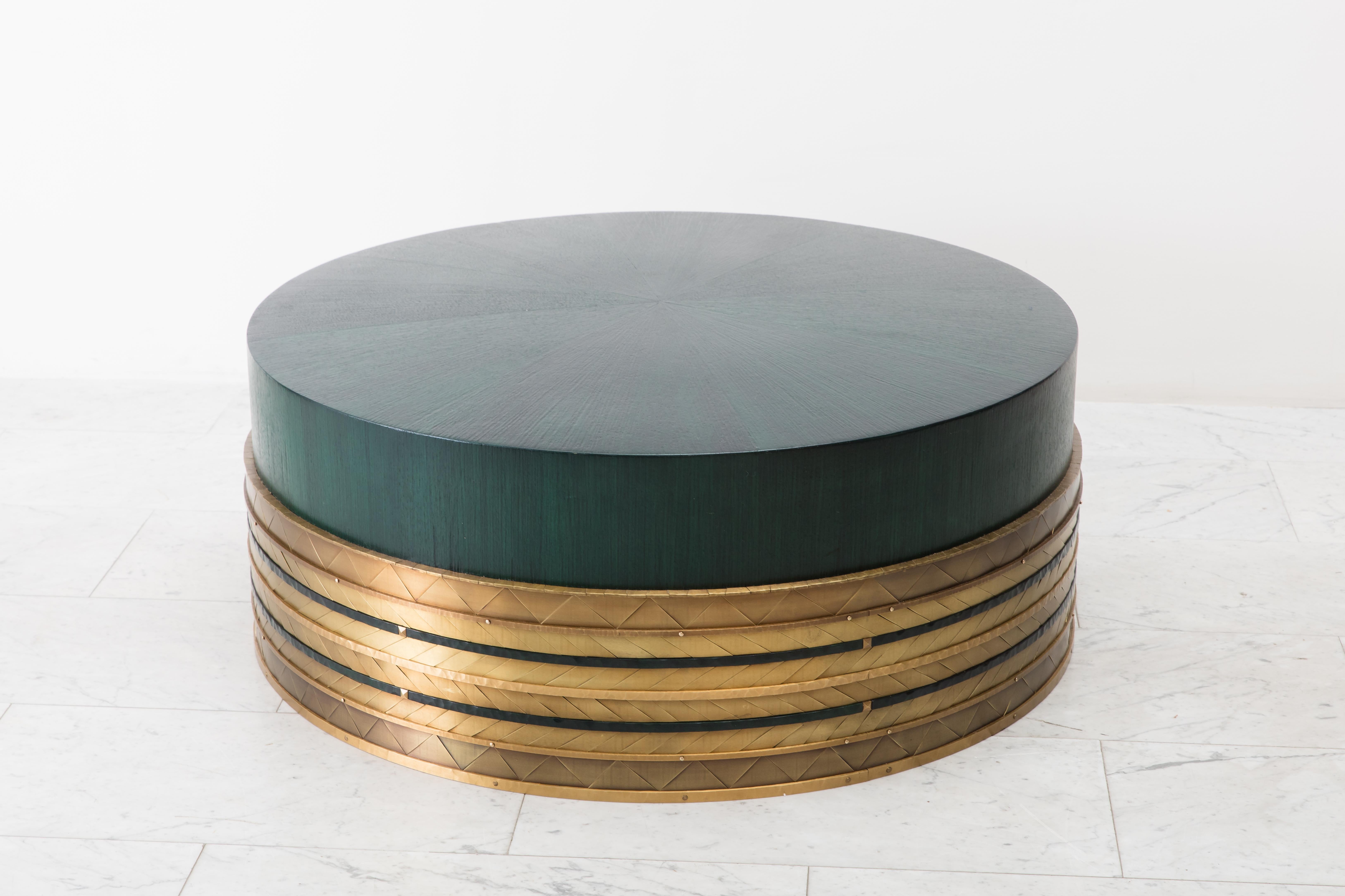 Damian Jones’s Nant Table functions perfectly as a coffee table or cocktail table. Its drum shaped form is sheathed in a mosaic pattern of hand-cut and laid brass “tiles.” Each tile has been patinated in varied colors and shades creating facets that