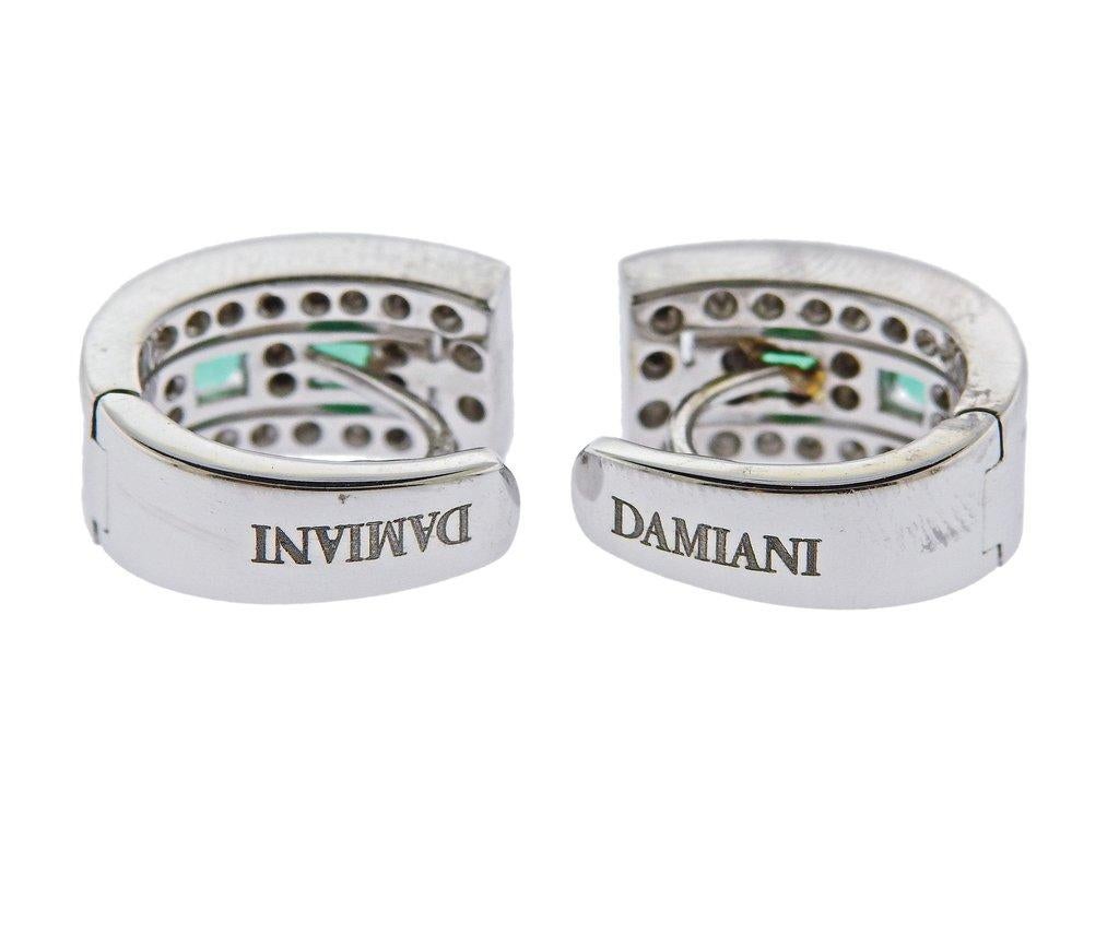 Brand new pair  of 18k white gold half hoop Belle Epoque earrings by Damiani, set with emeralds and approx. 0.25ctw in diamonds. Earrings are 16mm x 8mm. Weight is 10 grams. Marked Damiani, made in Italy, 750.