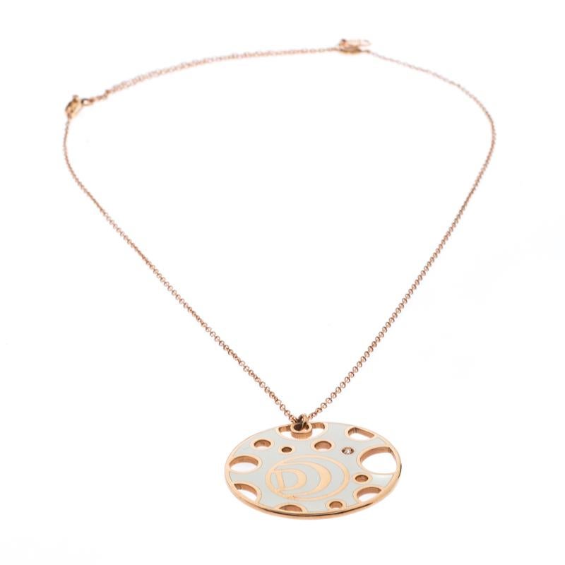 This necklace from Damiani's Damianissima collection exemplifies minimal style with modern aesthetics. It is made from 18k rose gold and the chain holds a gorgeous circular pendant detailed with white ceramic, round cutouts, the 'D' symbol and a