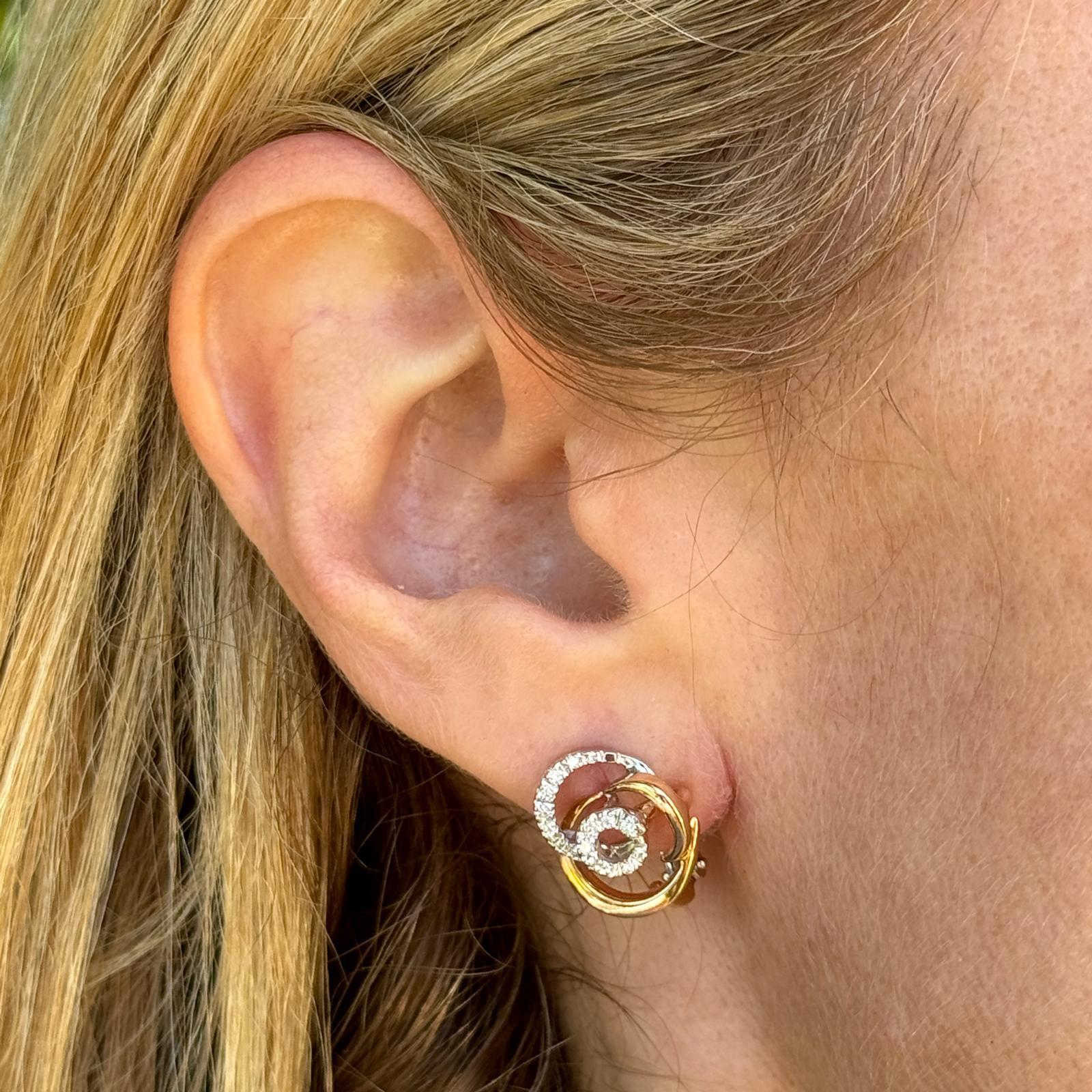 The Diamond Swirl two-tone gold circular stud earrings by Damiani are likely a dazzling and sophisticated pair of earrings, showcasing the brand's expertise in fine jewelry craftsmanship and design. The earrings feature a circular stud design,