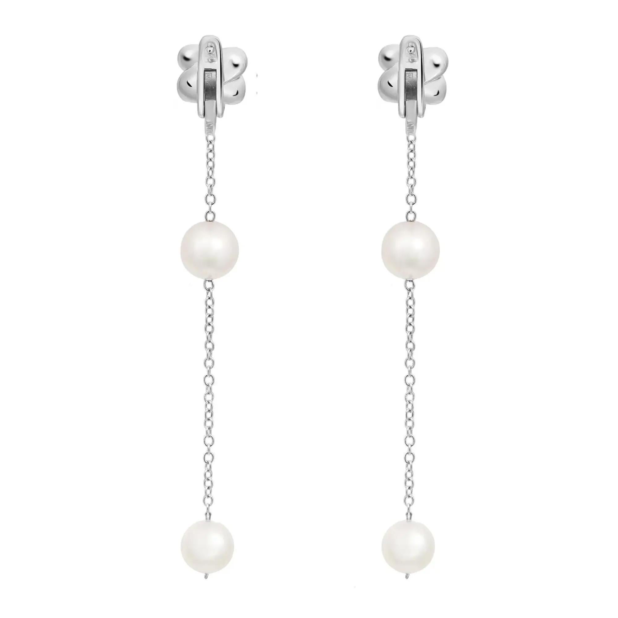 These wonderful pair of Damiani long drop chain earrings are designed in lustrous 18K white gold. These earrings feature pave set round cut diamond studded post with long drop chain embellished with two pearls. These earrings are studded with a