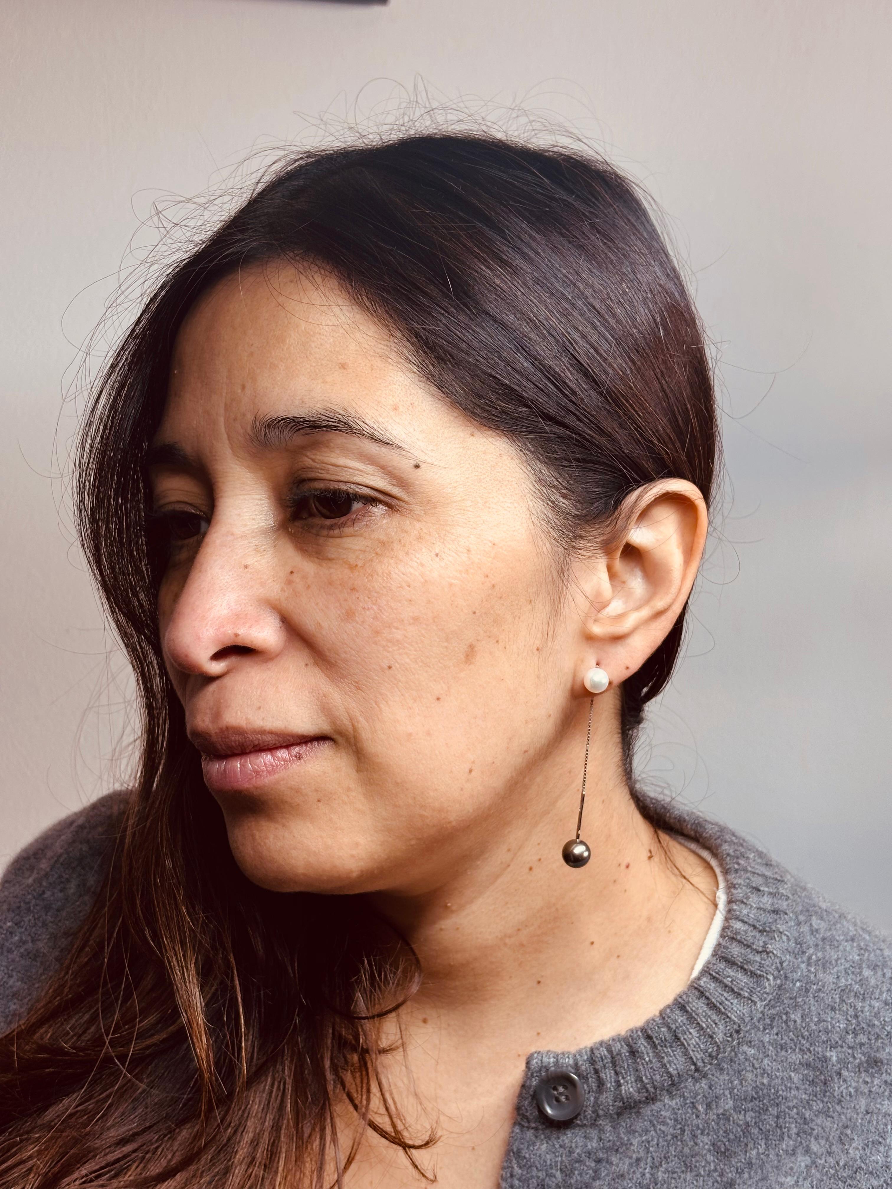 Longues boucles d'oreilles pendantes de la maison Damiani en or blanc 18 carats, quatre cultures noires et blanches.  de diamètre 8,75 mm et 7,30 mm respectivement. Forme ronde.
 Chaîne modèle vénitien et section rigide quadrangulaire.
Ils peuvent