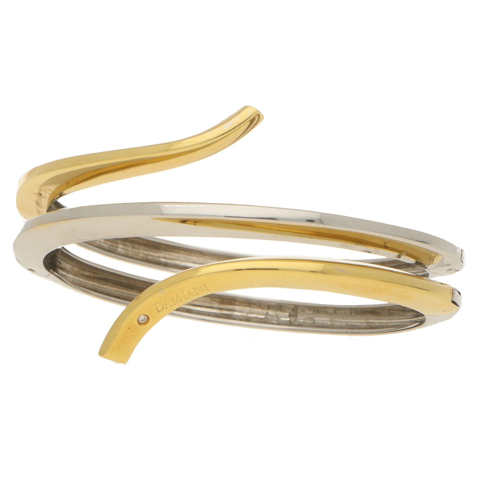 A highly unique Damiani Eden diamond bangle bracelet made of solid 18-karat yellow and white gold. 
This bracelet has an eccentric yet minimalistic design with a quadruple hinged fitting system. This makes the piece more secure whilst on the wrist