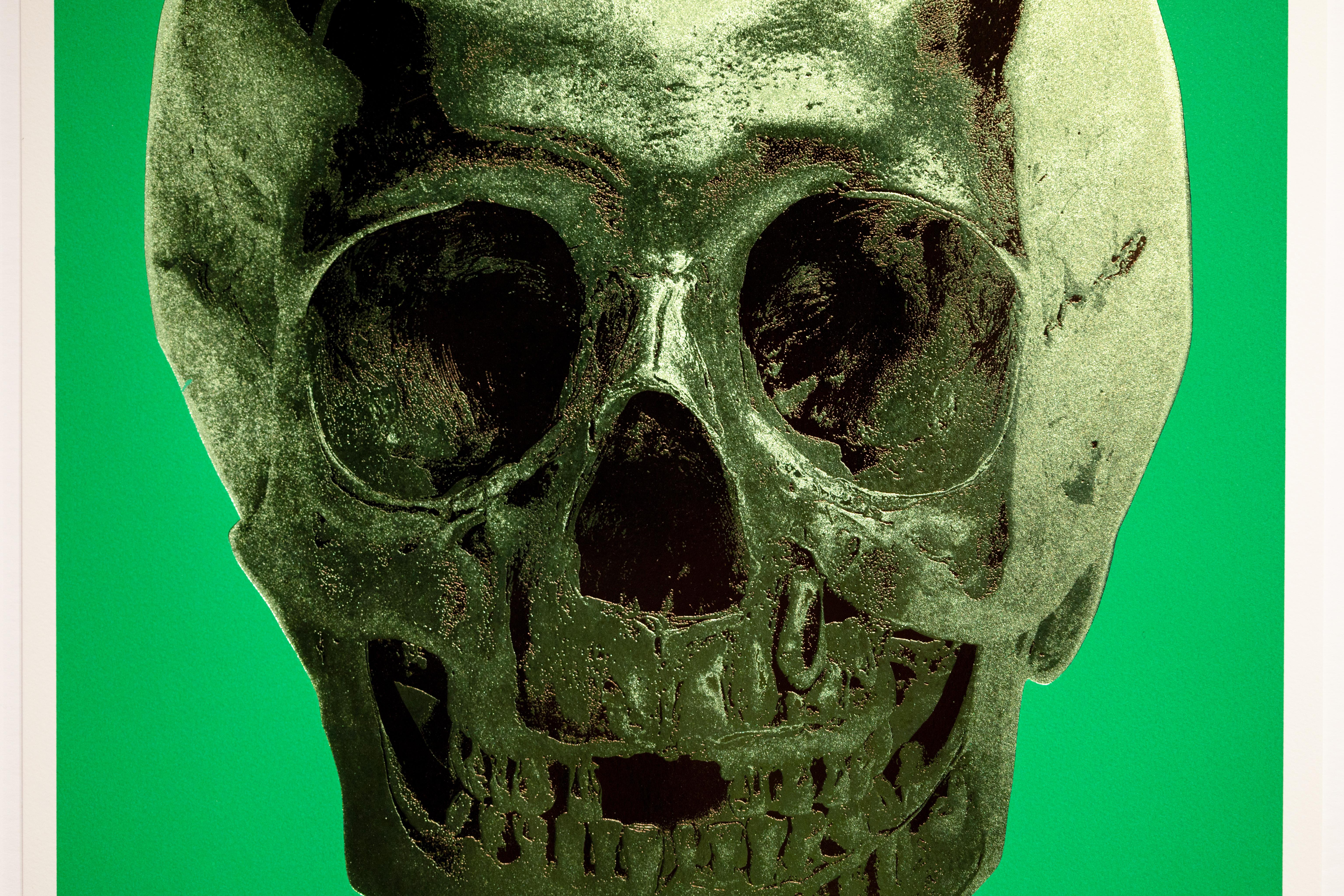 Using a combination of silkscreen printing, foil block, and glaze, this print of 'Til Death Do Us Part Skull' creates a distinctive texture and visual allure that enhances its powerful presence. The shimmering green skull contrasts vividly against a