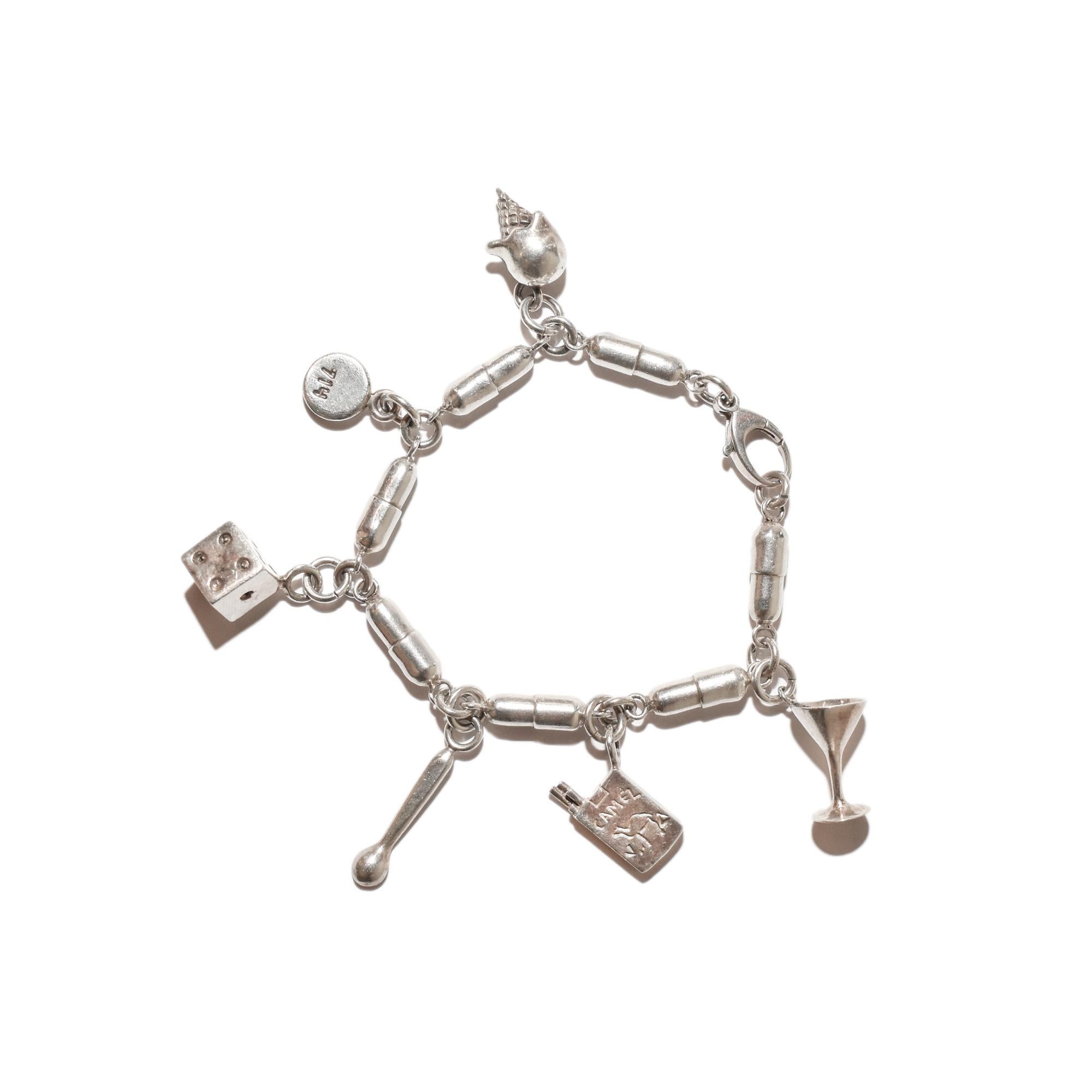 An extraordinary Damien Hirst style sterling silver pill link 'VICES' charm bracelet. Features a pill capsule shaped link design with six vice-related charms: a martini glass, a pack of camel cigarettes, a coke spoon, a die, a Quaalude pill, and an