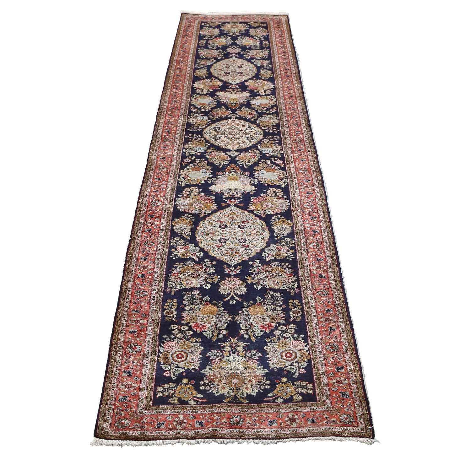 This vintage Qom Arsalani runner rug is a true gem of the weaving world. Crafted with a silk pile and silk foundation, it offers unparalleled luxury and durability, ensuring a velvety soft texture underfoot.

The rug features a mesmerizing medallion