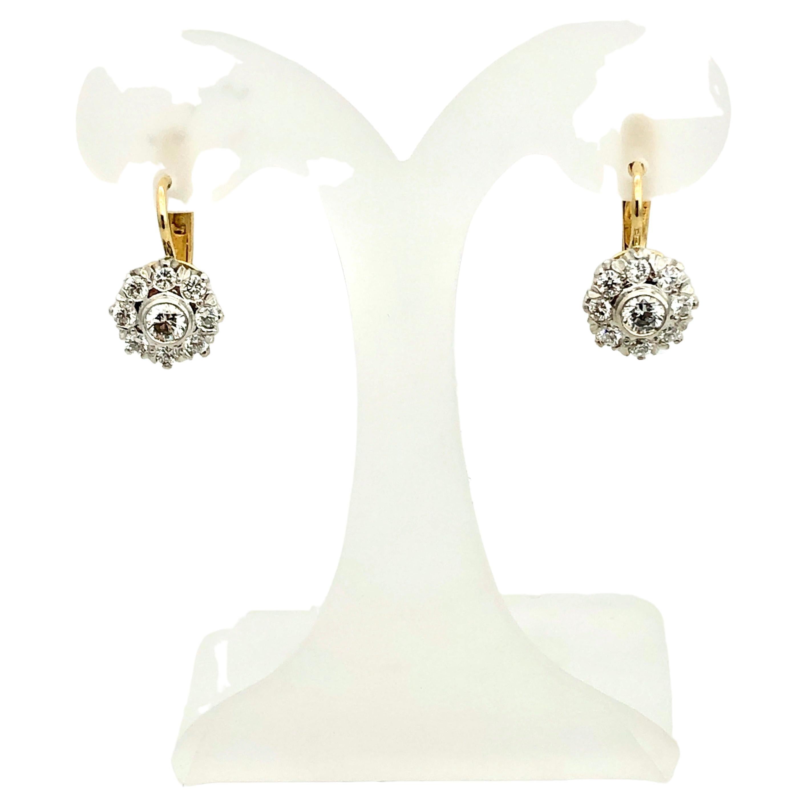 Classic hand made 18 carat yellow gold earrings with 18 sparkling brilliant cut diamonds
claw set in 18 carat white gold flowers, measuring 9 mm x 9mm.
Very safe continental snap-in lock
Setting thickness is 6.6 mm
Two centre diamonds are totalling