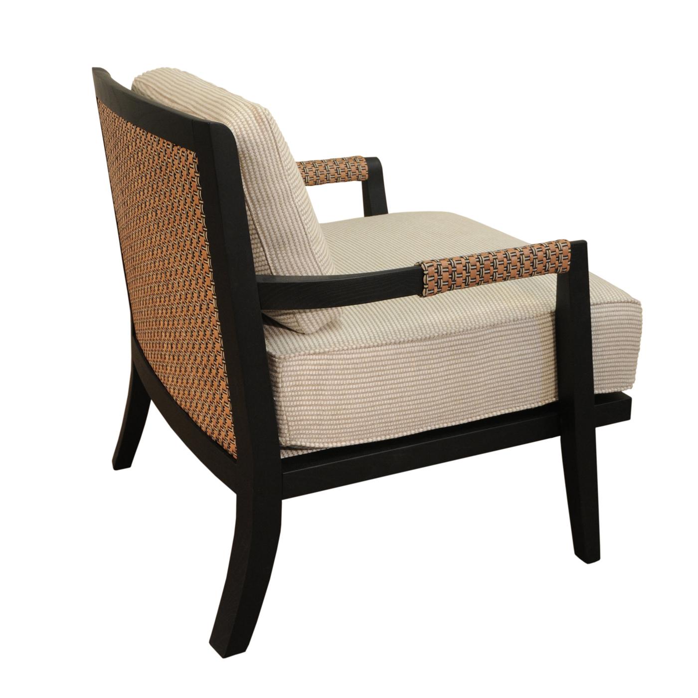 Testimonio de la elegancia clásica y la artesanía tradicional, este sillón es una pieza atemporal de sofisticado encanto. Fabricado en fresno macizo teñido, su respaldo y reposabrazos presentan un impresionante entrelazado de cuero y lino (también
