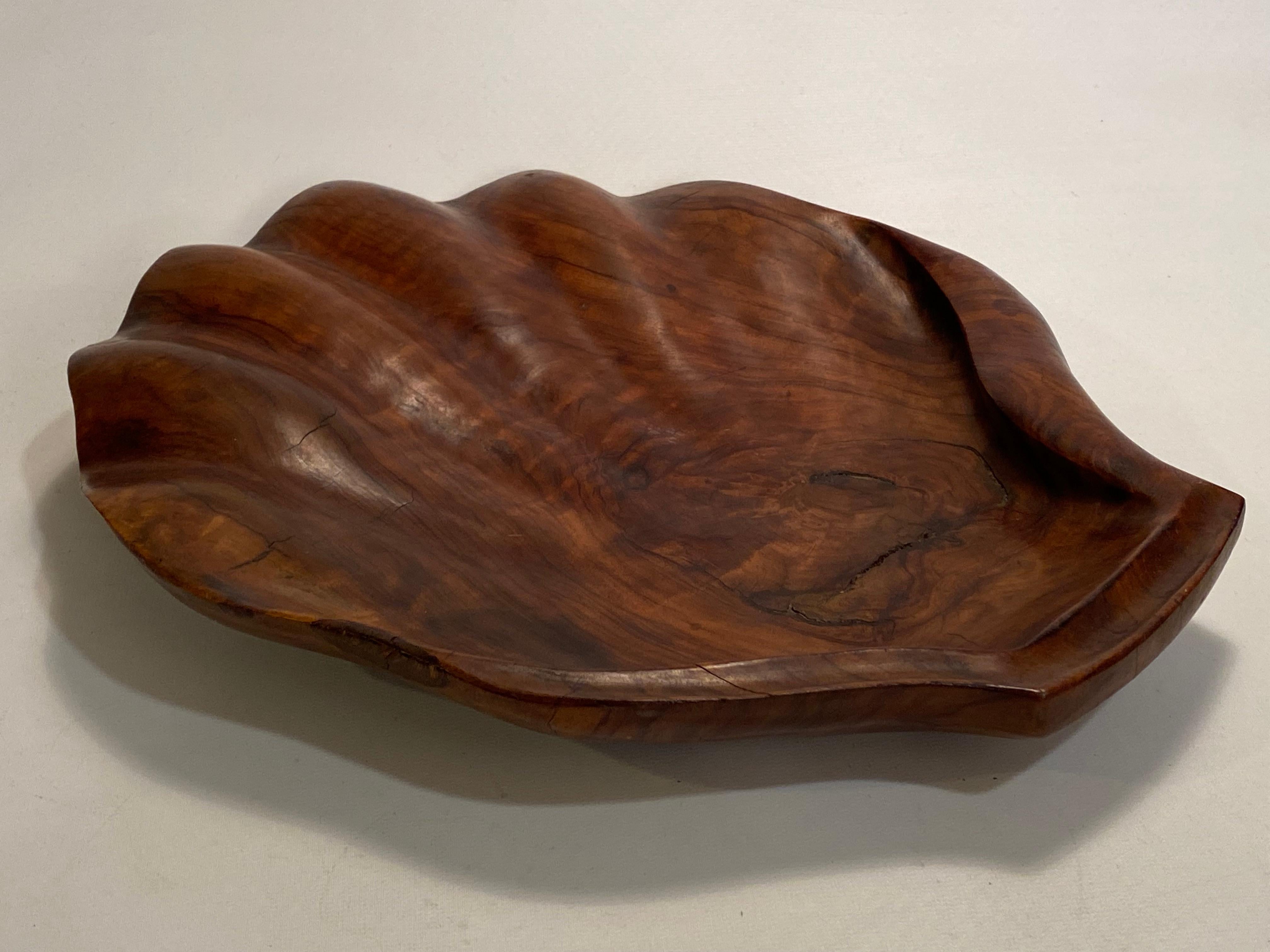 Carved solid crotch walnut scallop shell catch all/decorative platter. Signed with burn in mark, Creaciones, Barcelona, Spain, Dan Harner. Beautifully figured solid walnut sinuous carving. Circa 1950. This piece works well as a center piece on a