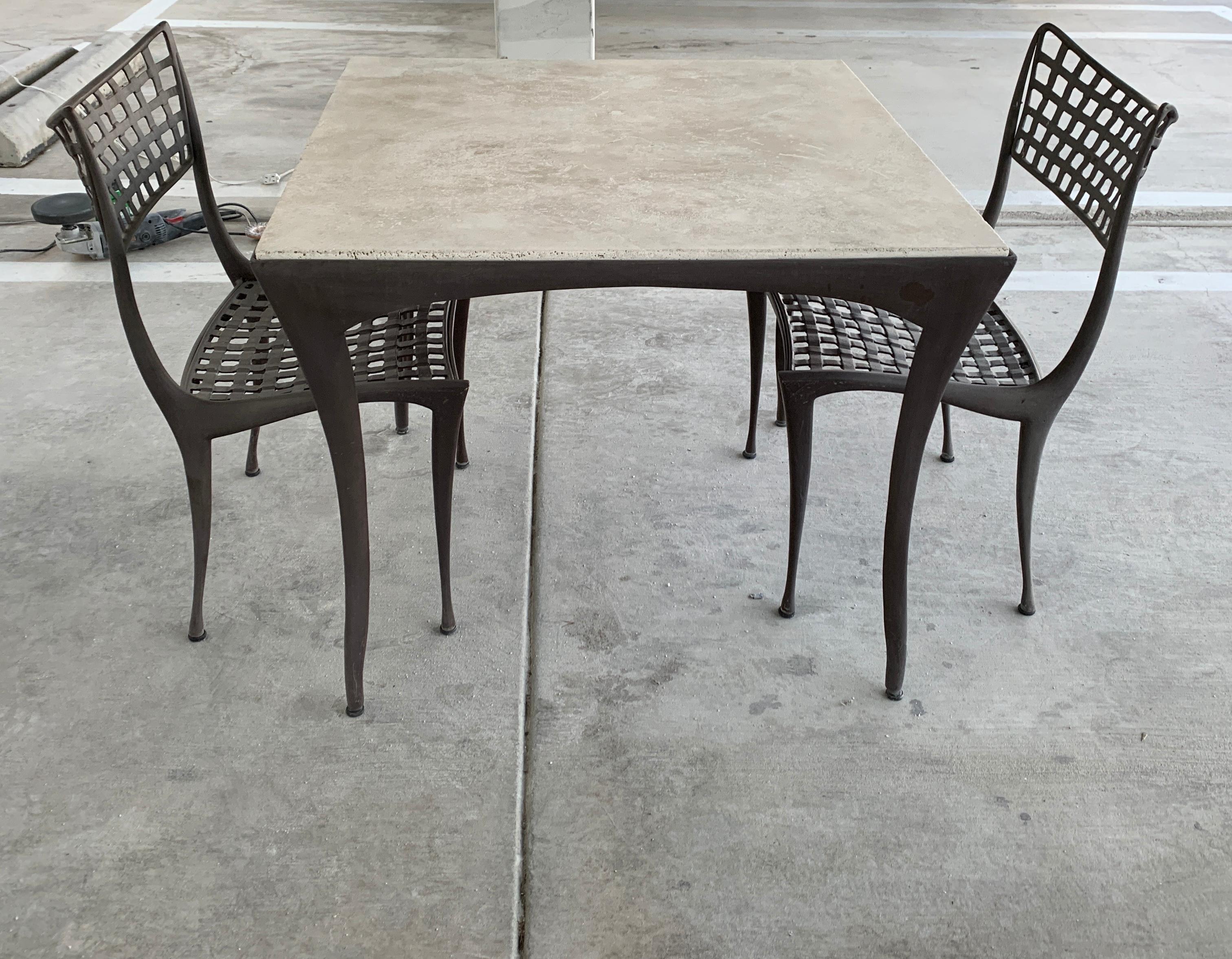 A Dan Johnson designed set for Brown Jordan. The original glass has been replaced with a beautiful piece of travertine. The chairs measure approximately 20 inches wide, 21 inches deep, 23 inches tall and 17.5 inches seat height. The table is 35.5