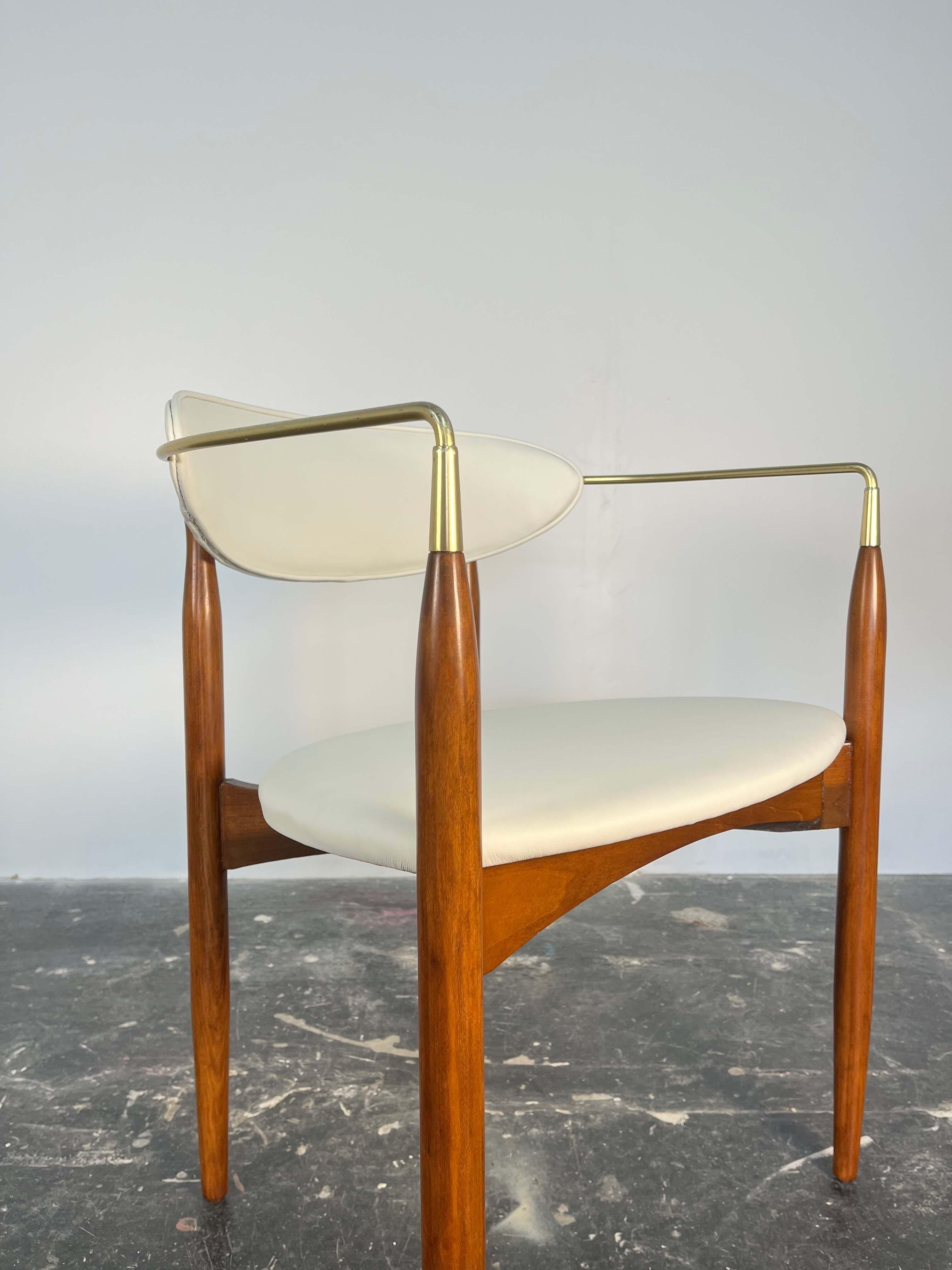 This is a gorgeous set of 4 dining chairs which were designed by Dan Johnson for Selig. Dramatic and curvilinear form, these chairs have the sweeping arms made of solid brass. Elegant tapered legs are finely carved from beech wood stained in a