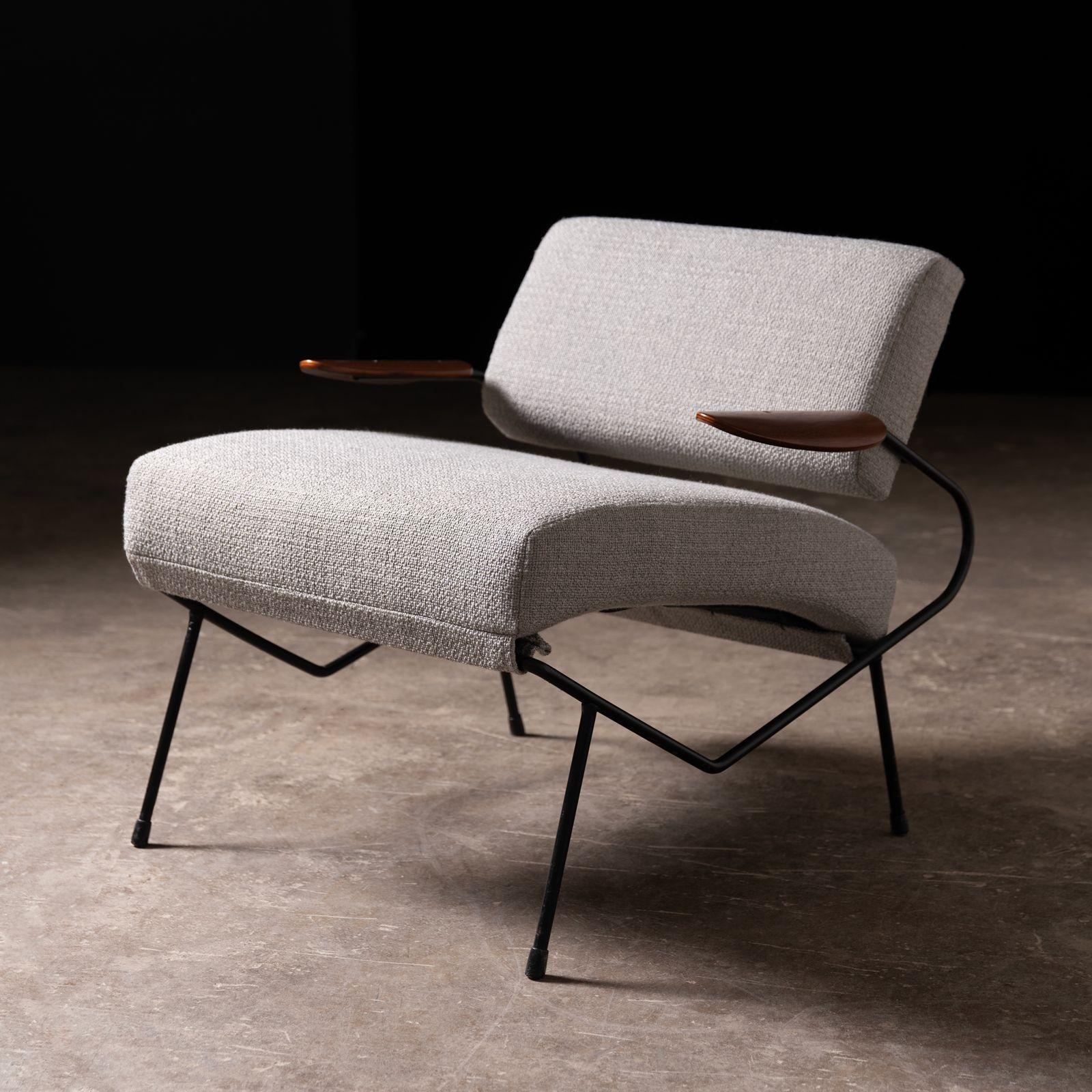 Early production lounge chair by Dan Johnson 1960s. The lounge chair is constructed of iron with sculpted walnut armrest and upholstered in a new Perennial fabric.