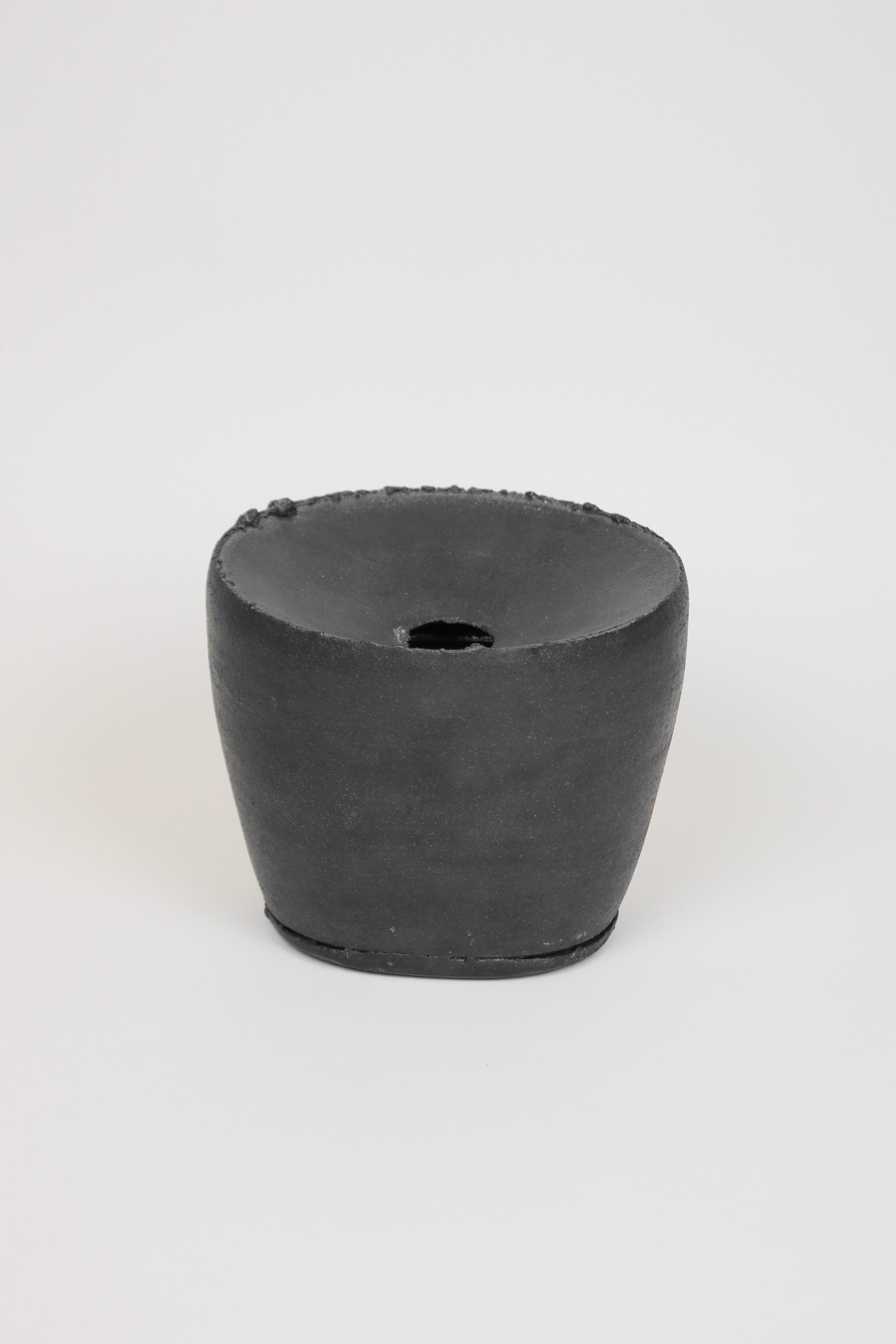 
Vase aus Steingut mit mattschwarzer Glasur und strukturierten Rändern.

Dan Kelly (*1953) wurde in den 70er Jahren an der Camberwell School of Arts and Crafts ausgebildet. Seine Arbeiten werden mit der Drehscheibe gedreht, dann manipuliert und