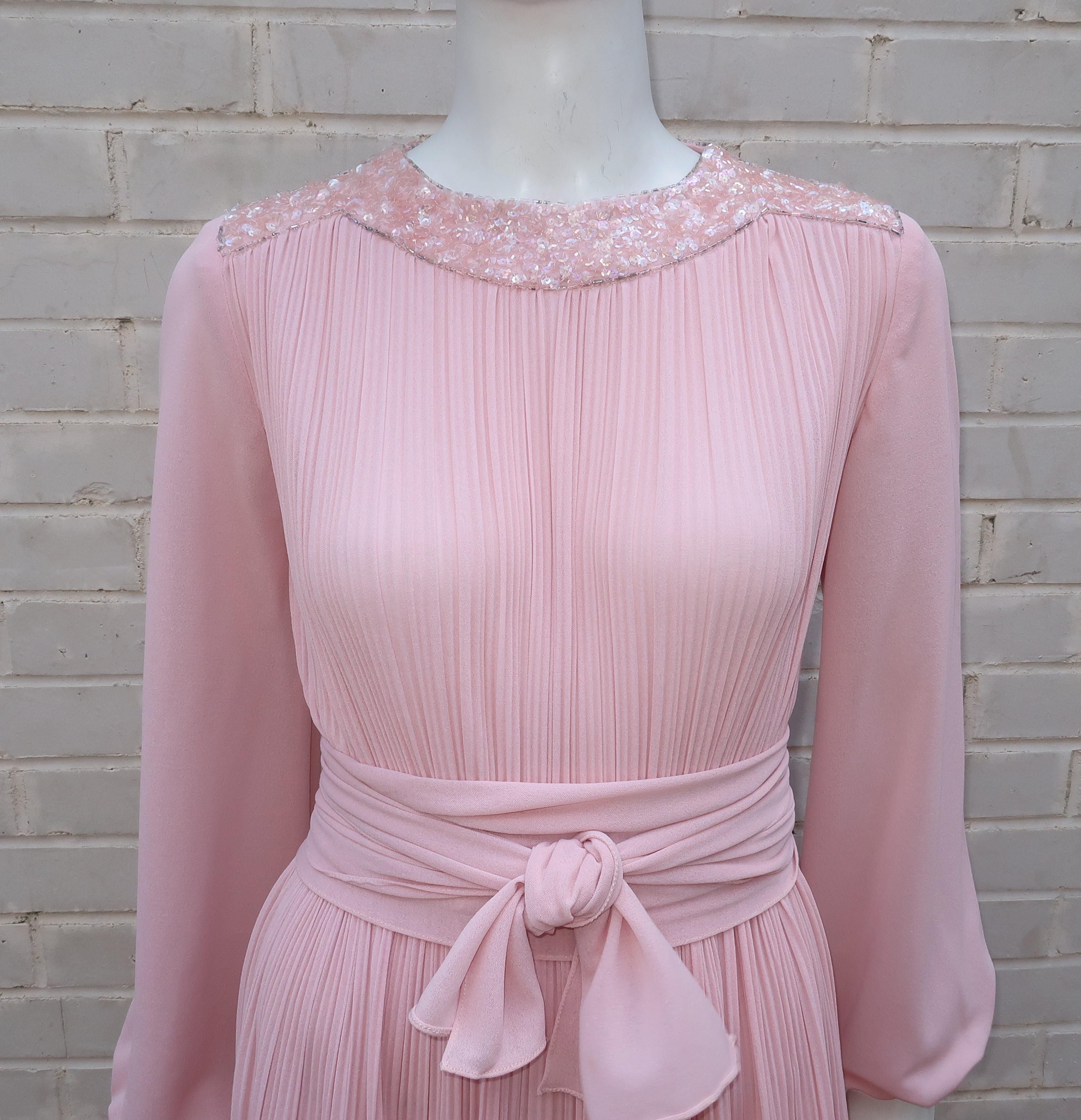 The combination of pale pink polyester crepe fabric and the subtly sexy drape of a delphos silhouette makes this Dan Lee Couture design an elegant evening look as perfect today as it was in the 1970's.  The pullover construction features hooks at