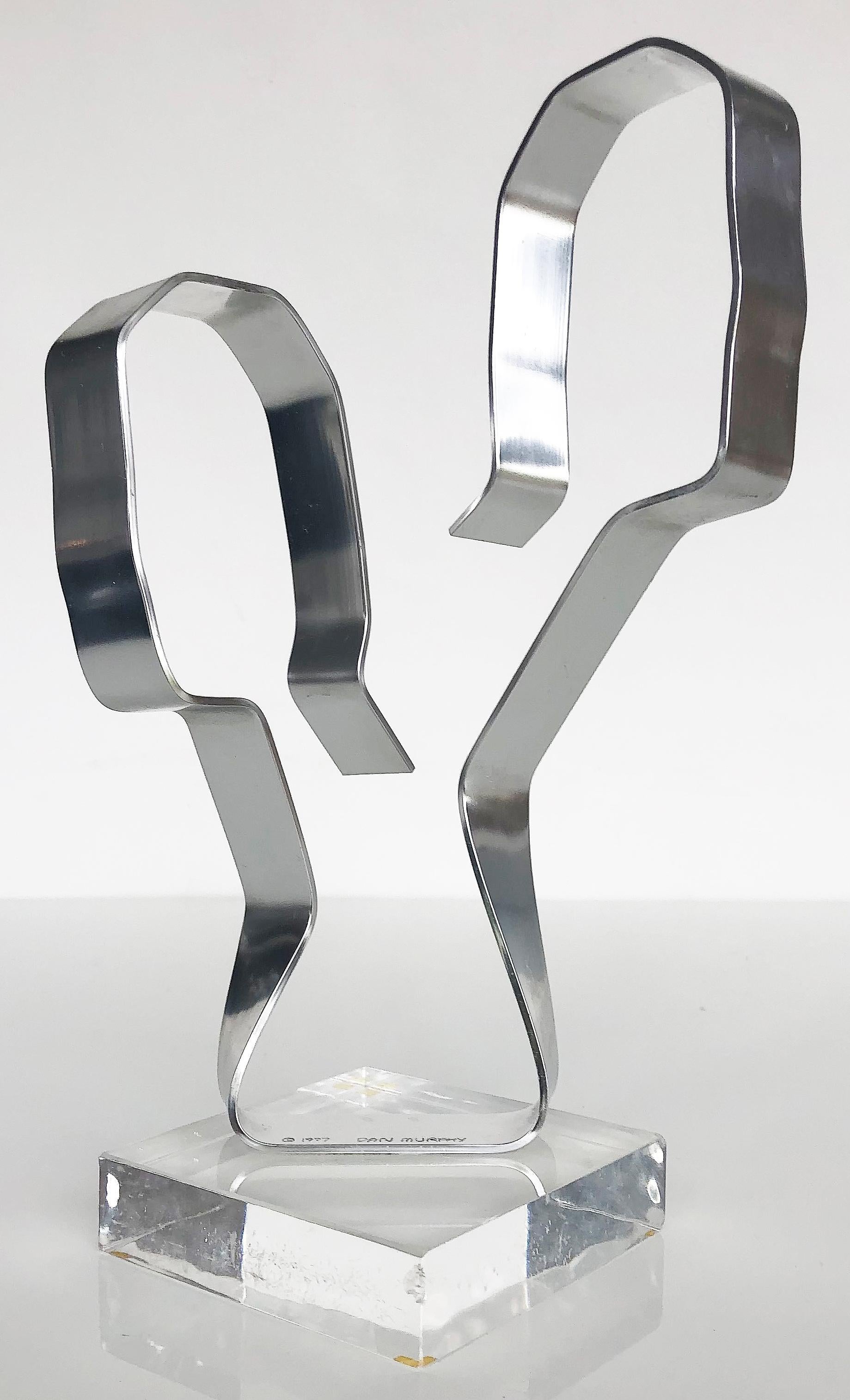 Dan Murphy abstract aluminum free-form sculpture on Lucite, signed & dated 1977

Offered for sale is an abstract polished aluminum free-form sculpture that is supported by a square Lucite base. The sculpture is signed at the bottom and dated