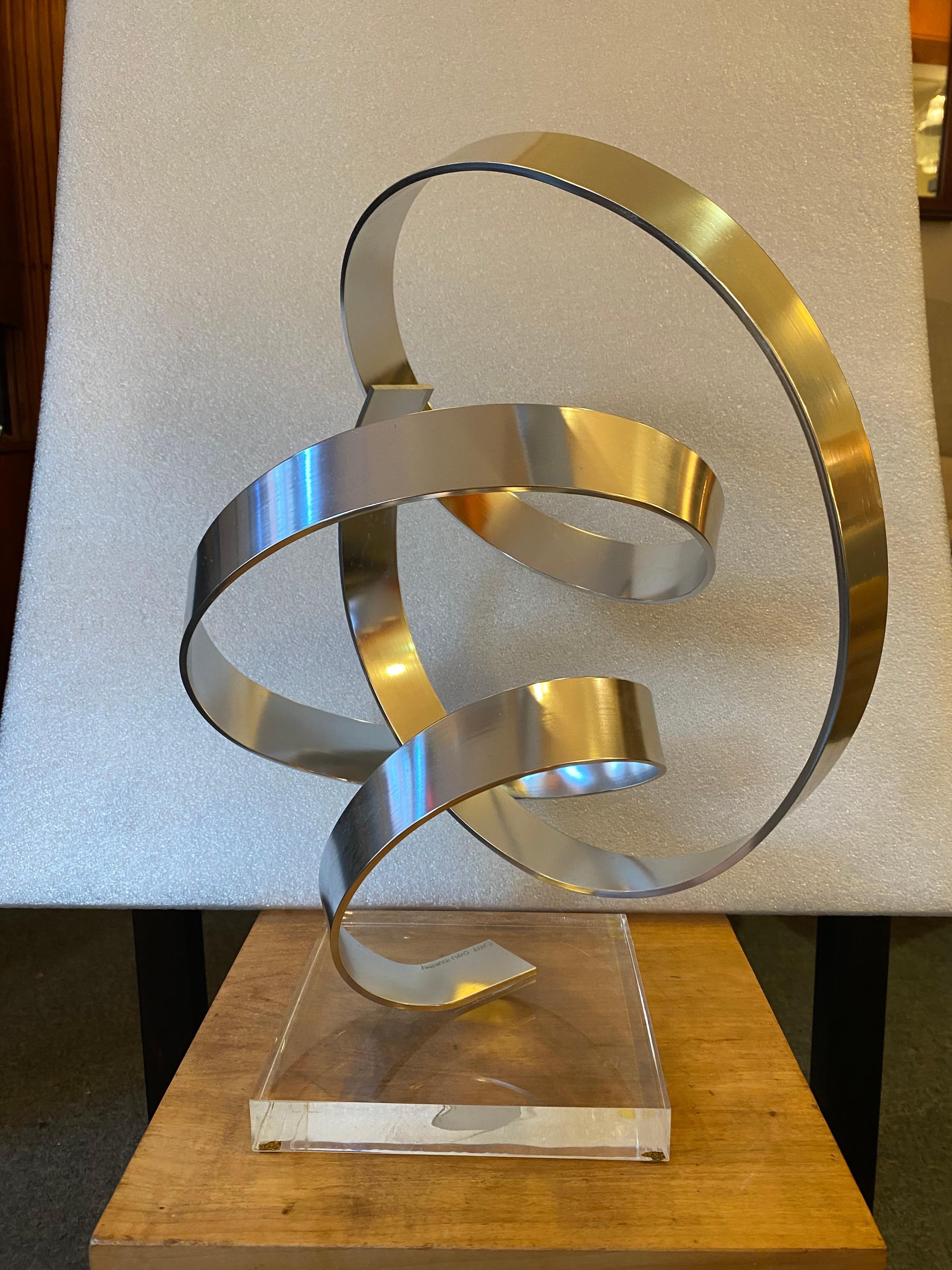 Dan Murphy Aluminum Sculpture.  Curly Twisting bands of aluminum form a sculpture that sits on a lucite base.  Signature to aluminum at bottom.