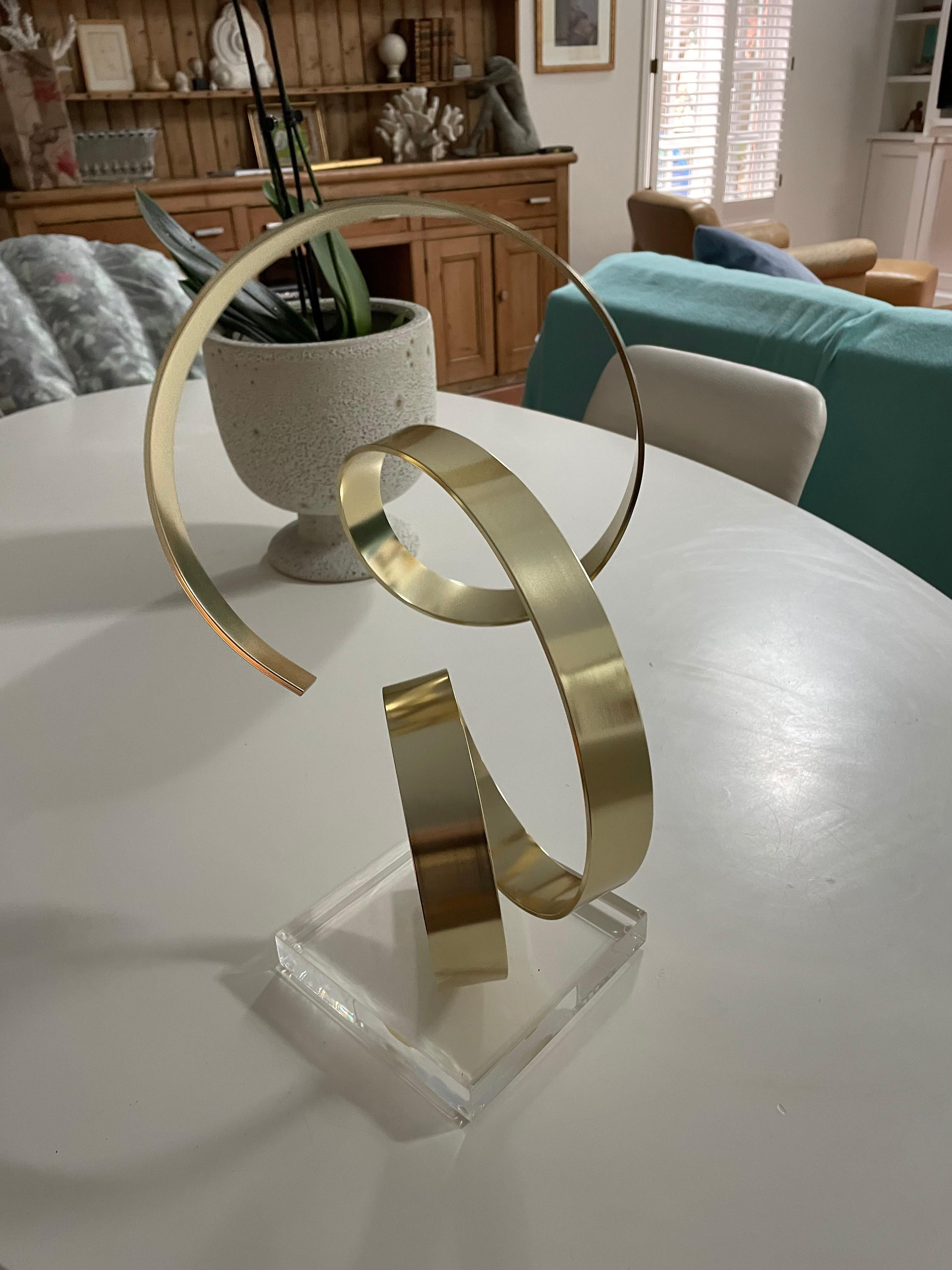 This is a great 1979 brass abstract sculpture on lucite base by Dan Murphy.