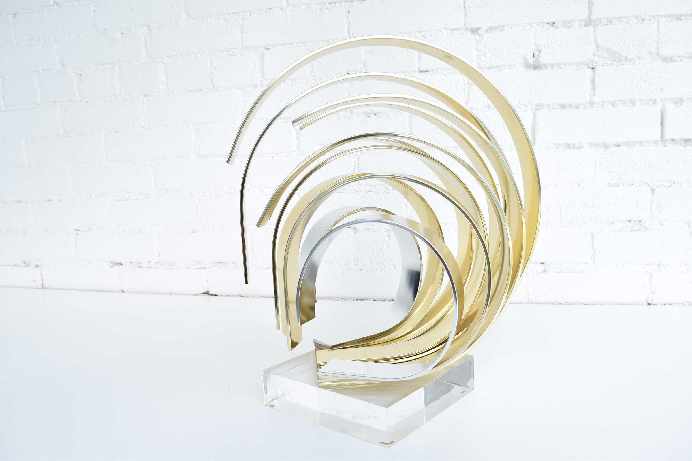 Dan Murphy signed and dated 1991. Aluminum ribbon sculpture, coated half in silver and half in gold, mounted on Lucite base. Measures: 15.5