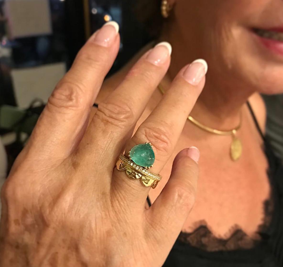 The Dana Bronfman X Muzo Emerald Fairmined Gold Agra Crown Ring is the result of a modern collaboration between the designer Dana Bronfman and ethical mine-to-market Colombian producer Muzo. The ring features a 2.96 tcw cabochon Muzo emerald with