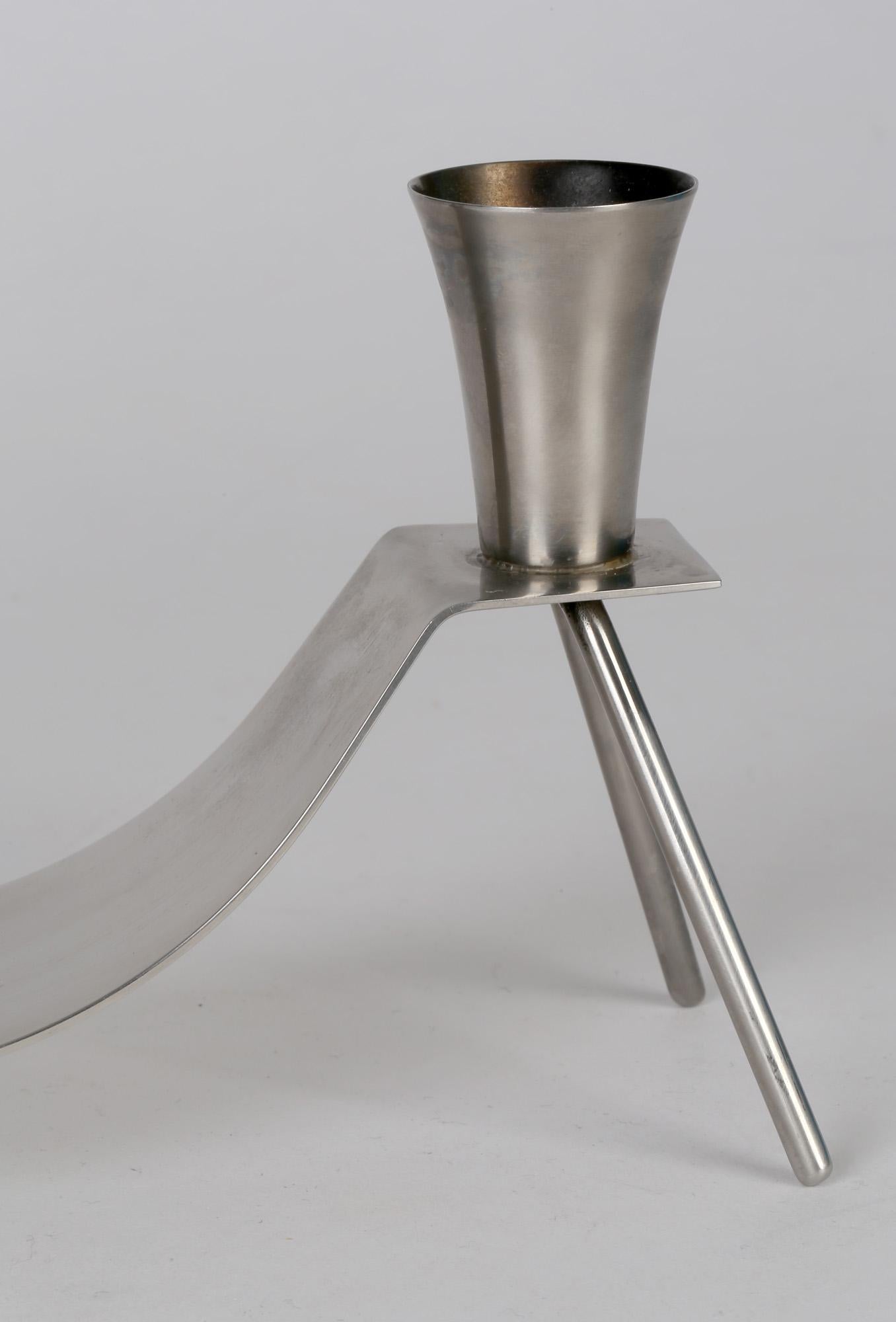 Un chandelier double en acier inoxydable brossé danois du milieu du siècle, très élégant, par Dana. Le chandelier jumeau est monté sur une tôle d'acier plate façonnée reposant sur quatre pieds de type trépied. Ce design simple mais très efficace est