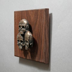 "3 teschi" (2023) di Dana Younger, scultura in bronzo a rilievo con teschio