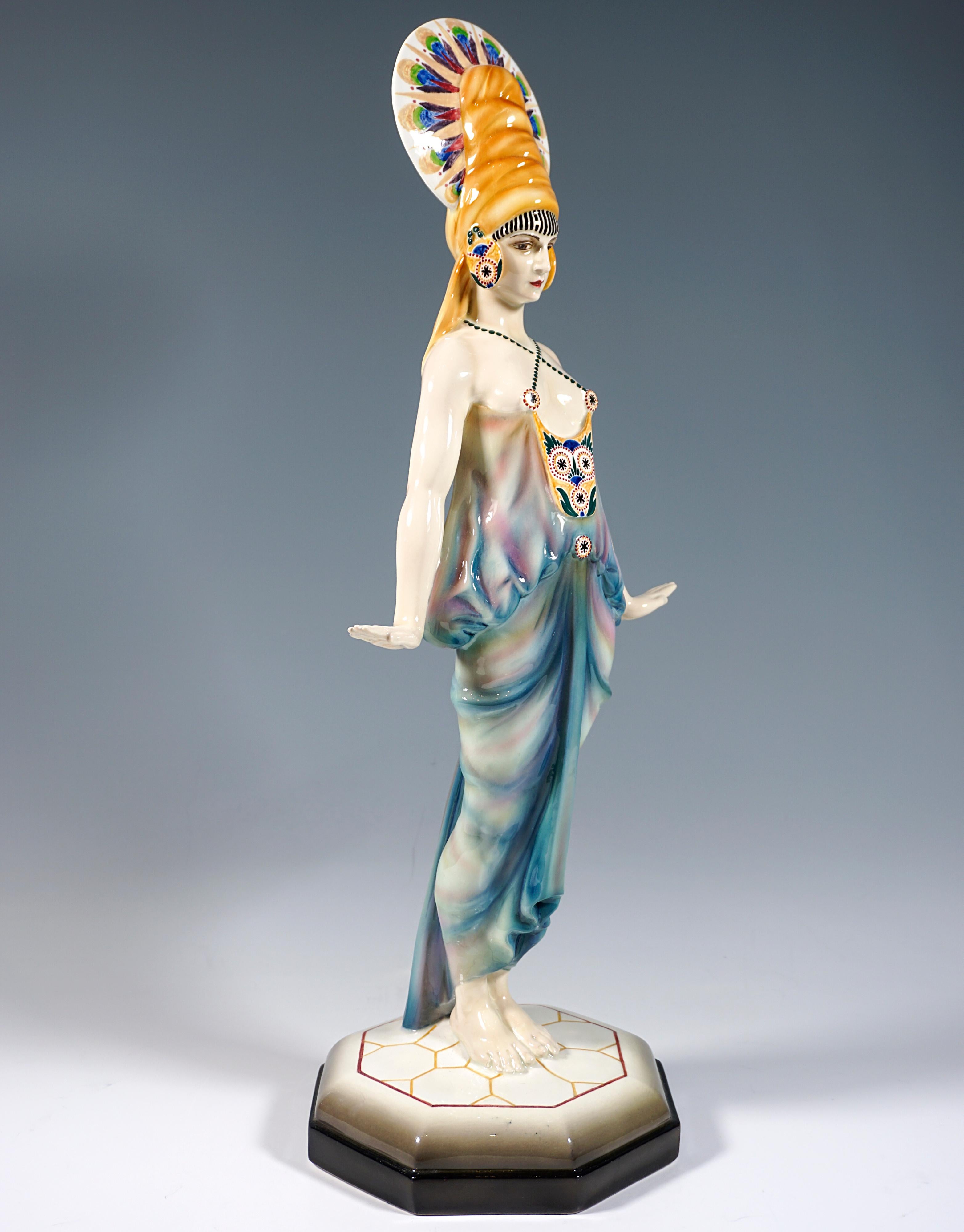 Exceptional Art Déco model of the Goldscheider company, which was executed only extremely rarely, and does not appear in the catalog of works:

Dancer posing upright with elaborate headdress in exotic costume softly embracing the body: Top attached