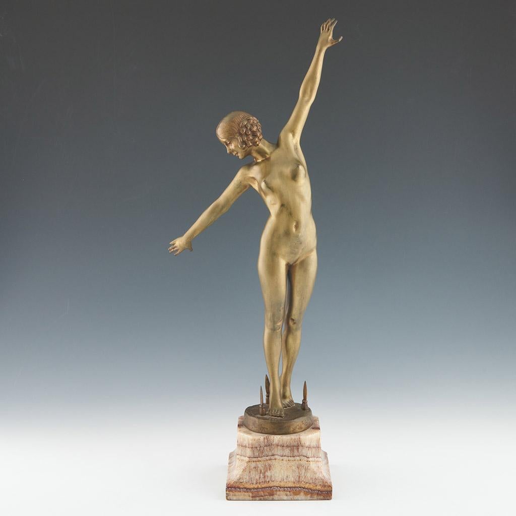 Sword Dancer an Art Deco bronze figure of a nude lady with arms outstretched, delicately stepping over a circular bronze base with three protruding spear heads. Set over original marble base. Signed F Ouillon Carrère to bronze and dated 1919.