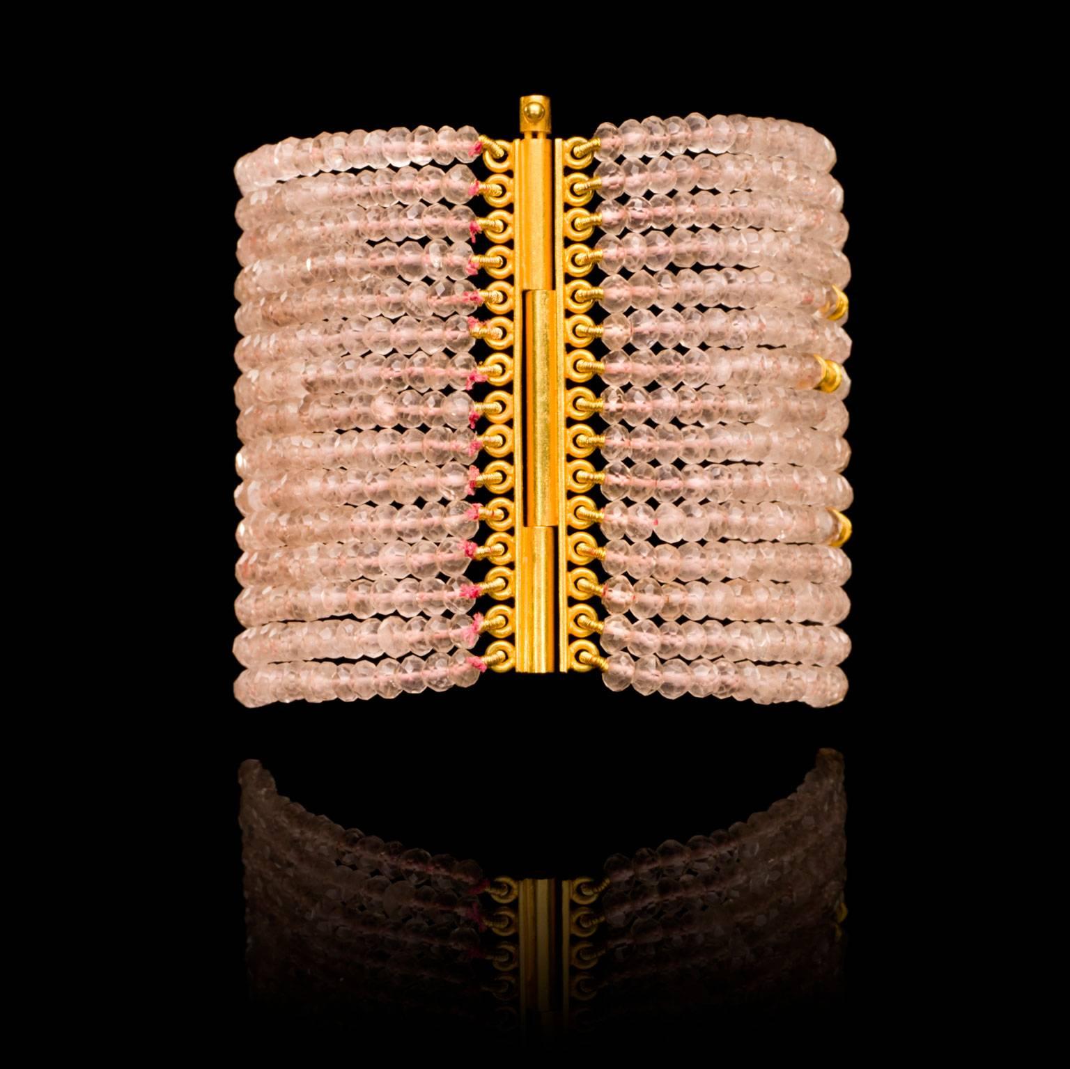 An 18k gold and rose quartz cuff bracelet with a traditional Indian clasp.  The cuff is 6.5 cm, 2.55in wide and 18cm, 7.08in long. Gold beads mingle with rose quartz beads in this versatile hand crafted piece which will effortlessly take you from
