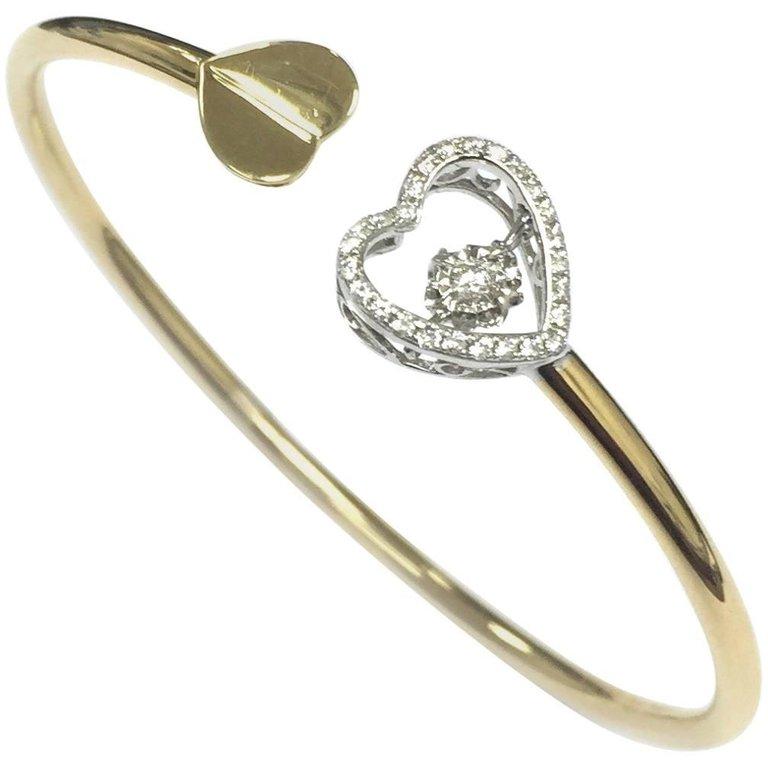 Dancing Heart Diamond Twist Style Bangle by Cartmer Jewellery

Beautifully designed Two-Tone Bangle that has a dancing diamond that moves as your hand moves shaped as a heart.
27 Diamonds 0.23 Carat
18 Carat Yellow and White Gold (Approx. 6.2cm