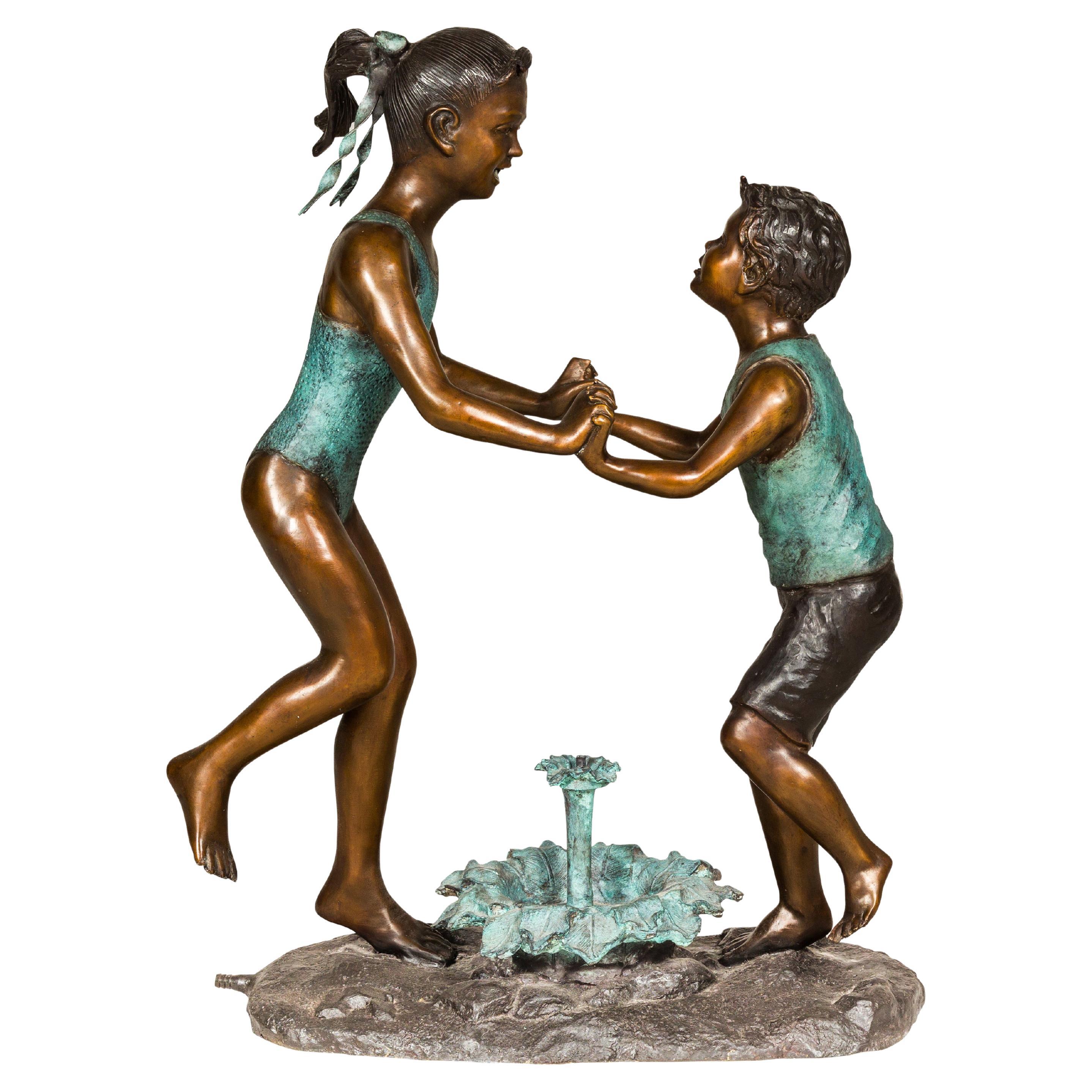 Tanzende Freunde, patinierte Bronzeskulptur einer Gruppe als Brunnen, geriffelt als Brunnen