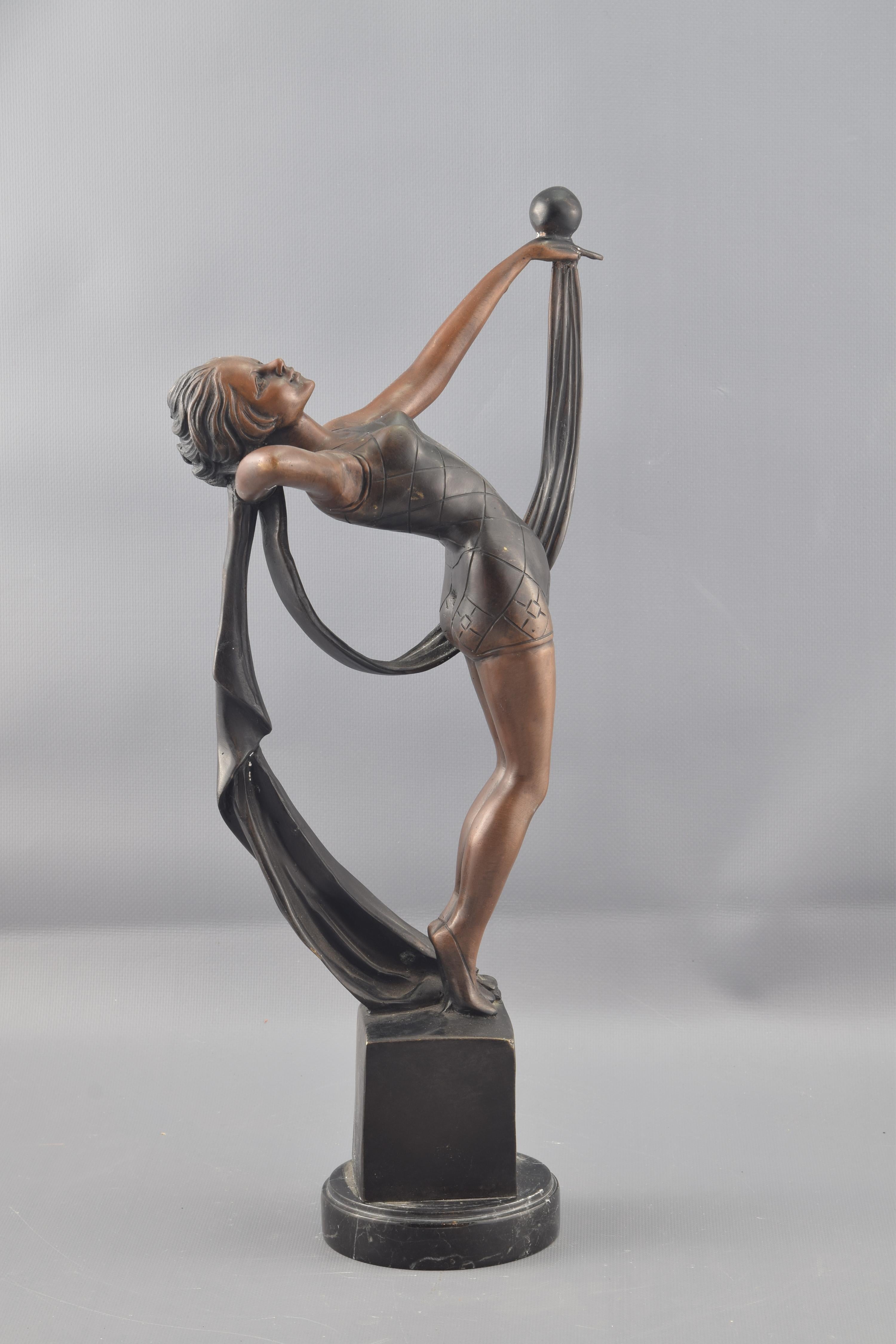 Dancing girl, bronze, after Art Deco models.
A pedestal with square base and rectangular body elevates the female figure that is standing on it. The lady is dressed in shorts and maillot adjusted to the body, tilting her torso backwards and raising