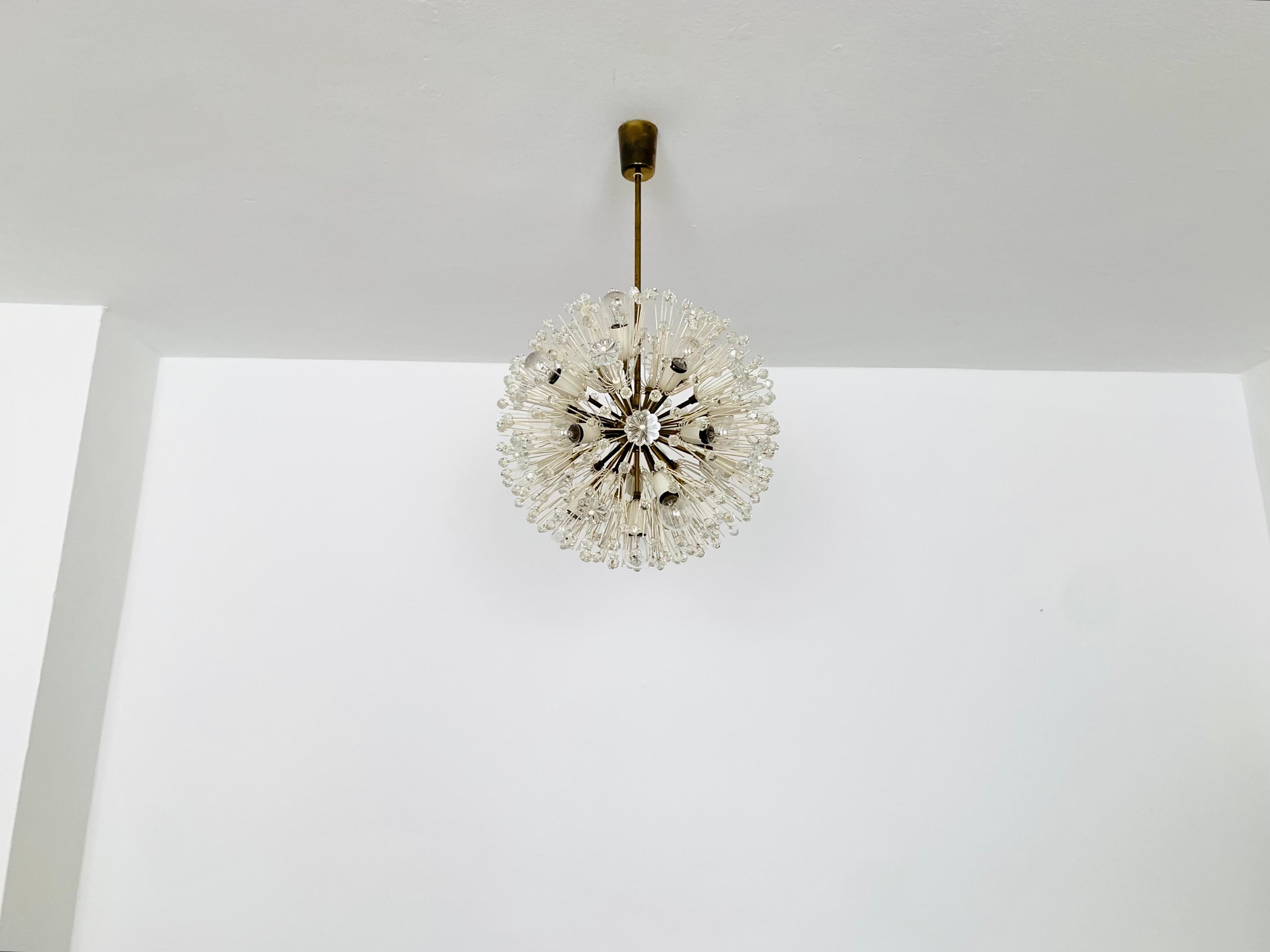 Wonderful chandelier from the 1950s.
The lamp with its lavishly decorated flowers and brass details has a very luxurious look and sparkles particularly beautifully.
The design and the materials used create a great glittering light.
A stunning