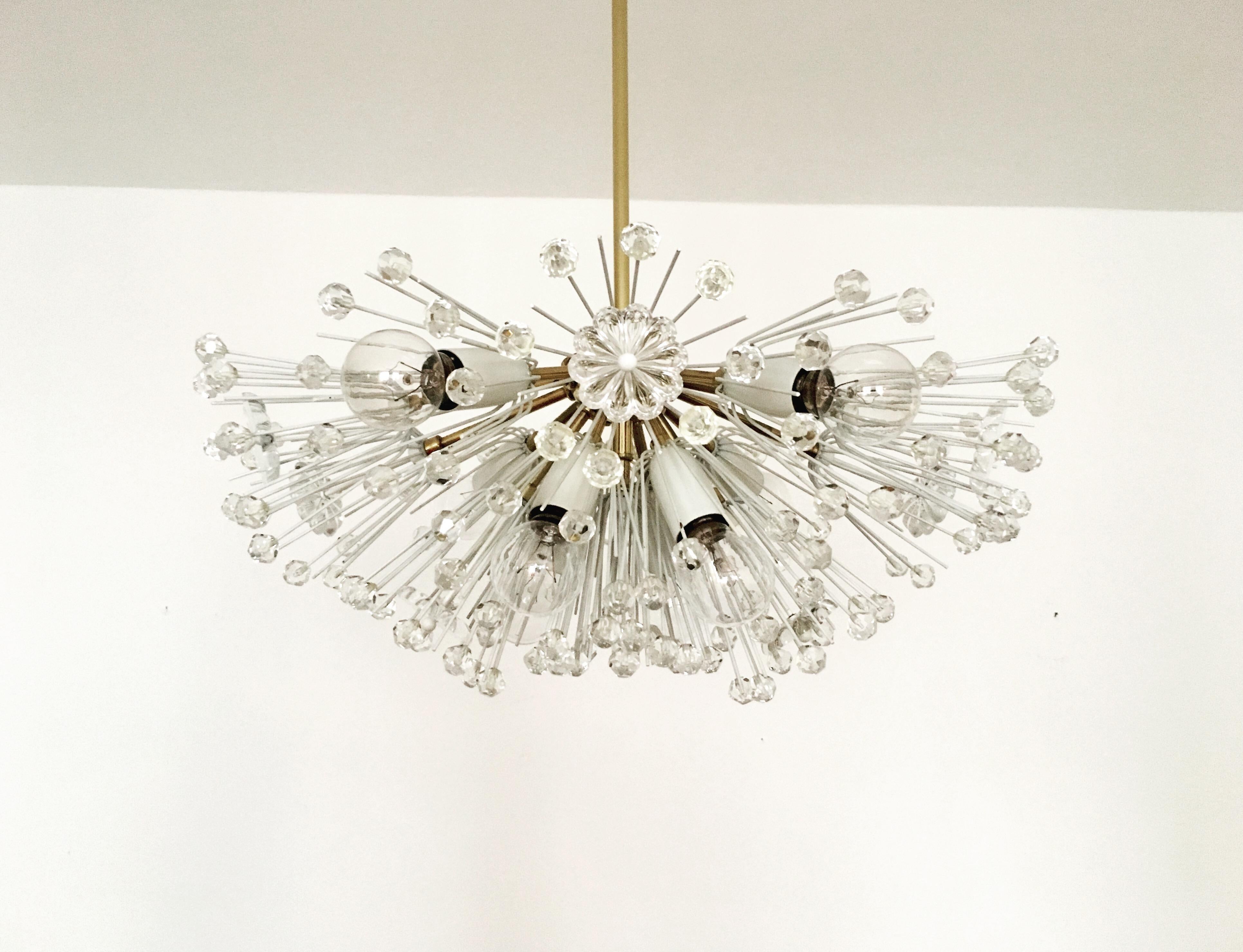 Wonderful chandelier from the 1950s.
The lamp with its lavishly decorated flowers and brass details has a very luxurious look and sparkles particularly beautifully.
The design and the materials used create a great glittering light.
A stunning