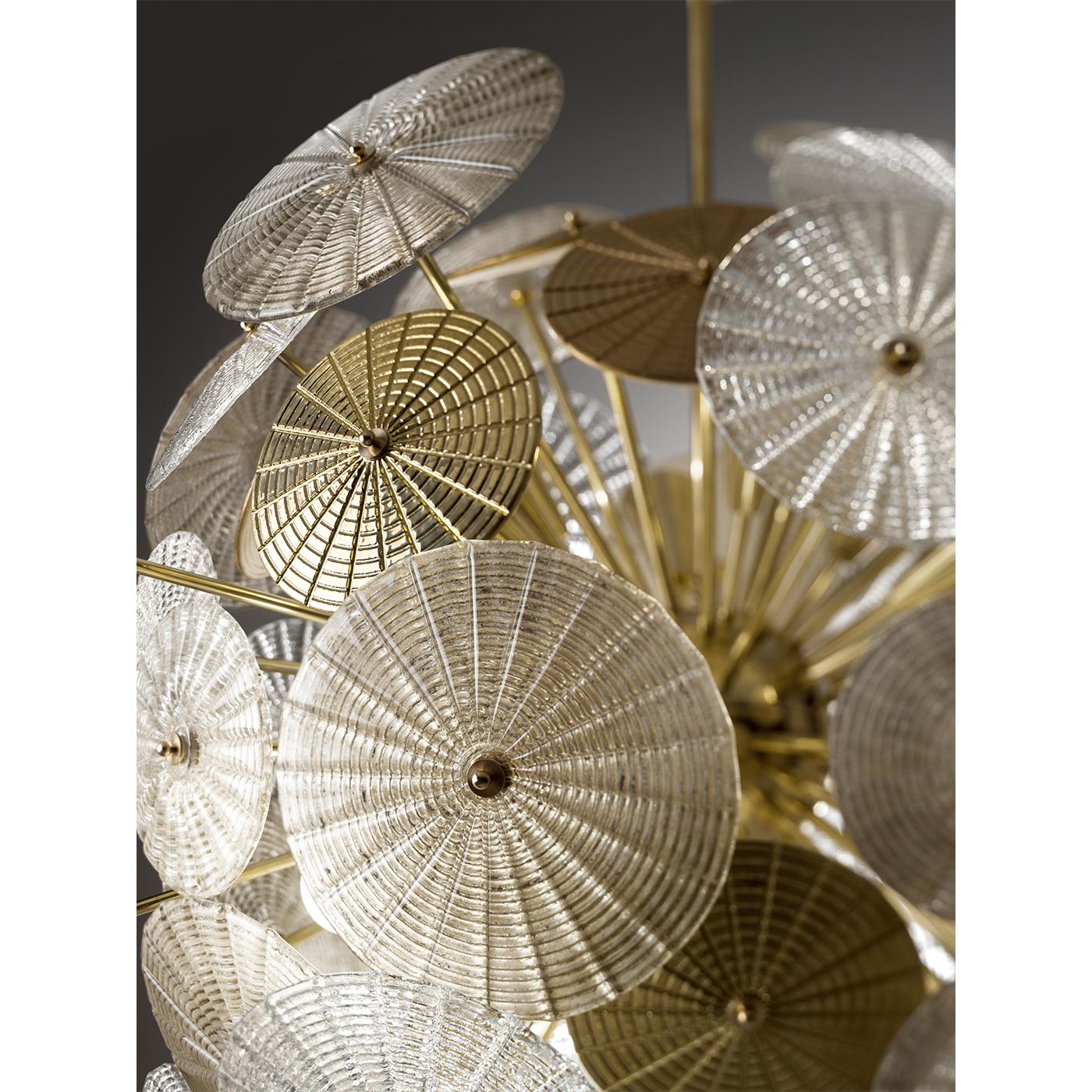 Masterfully translating into a contemporary design the delicate silhouette of a dandelion, this chandelier is a superb object of functioning decor. It features 16 lights and a spherical shape that combines a brass structure with porcelain and