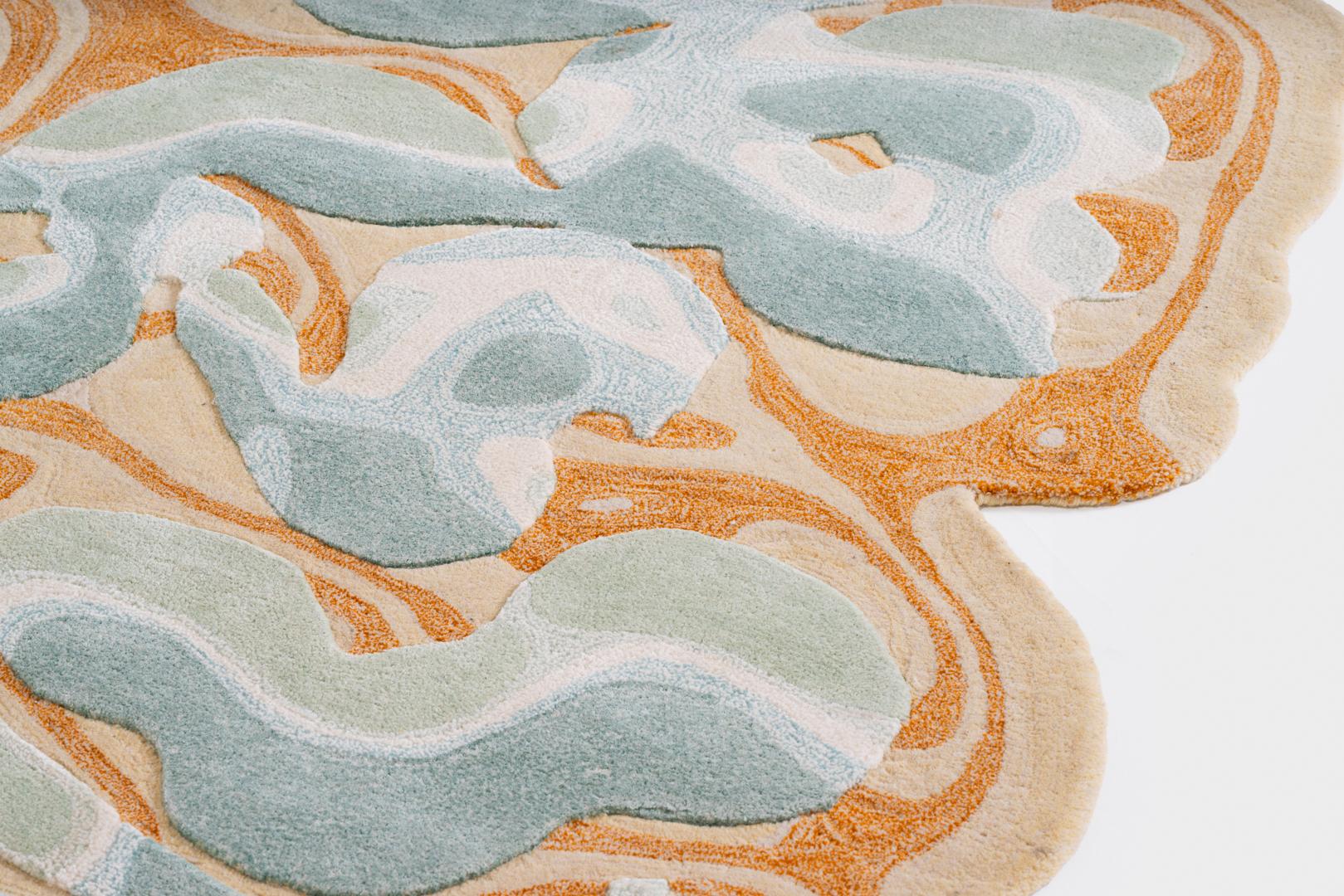 Esta alfombra tejida a mano juega con la técnica y la ilusión óptica de
una decoración hinchada que emerge del fondo. Formas fluidas y una mezcla de
Los colores fríos y cálidos añaden profundidad y movimiento, mientras que los degradados realzan
el