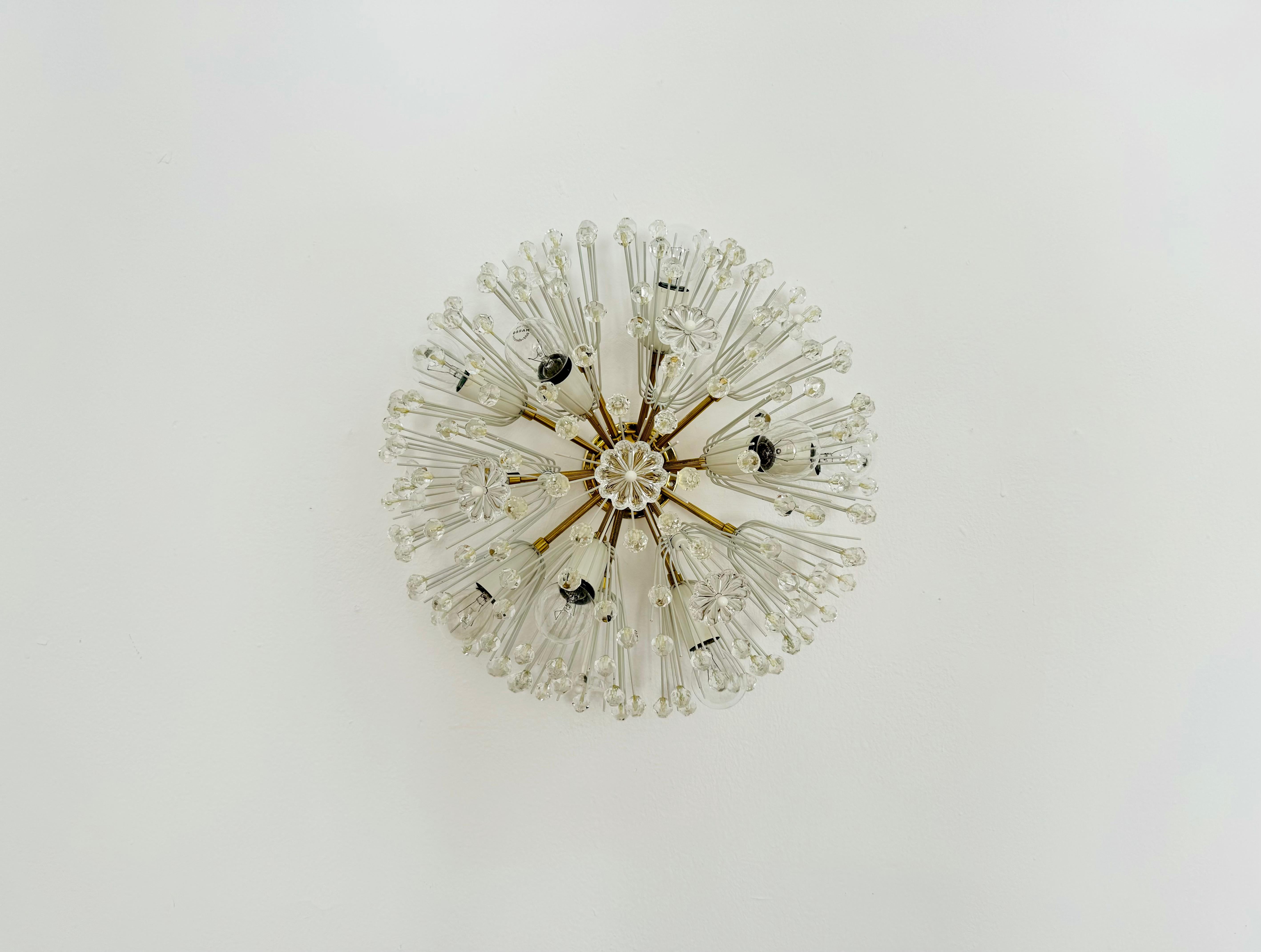 Very beautiful dandelion wall lamp or ceiling lamp from the 1950s.
The lamp with its lavish flowers and brass details has a very luxurious appearance and sparkles particularly beautifully.
The design and the materials used create a great glittering