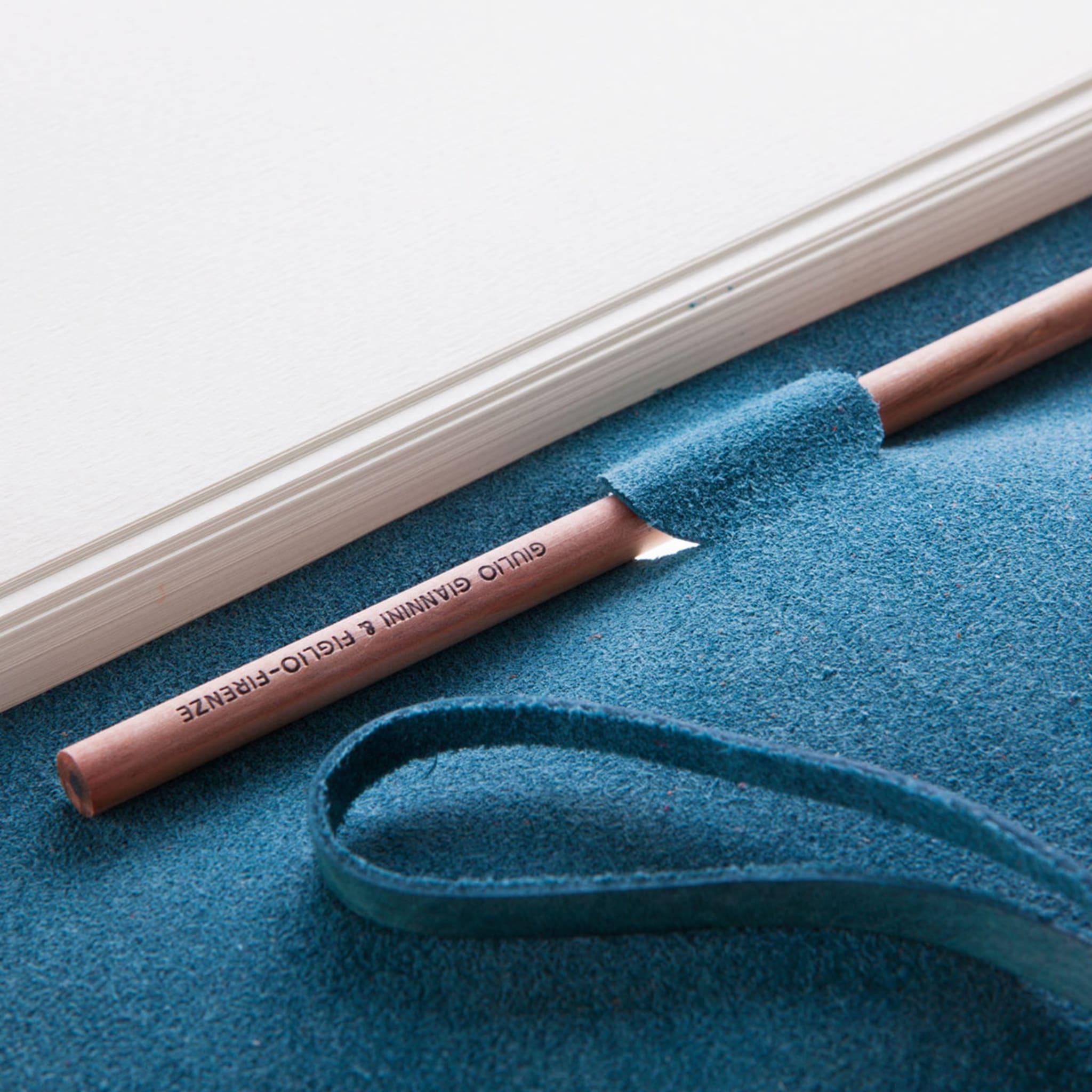 This is an elegant notebook bound in a debonair hue of blue leather by Florentine bookbinder atelier Giannini. The cover is made using the ancient technique of vegetable tanning, and the plain ivory parchment paper within is fastened by a leather